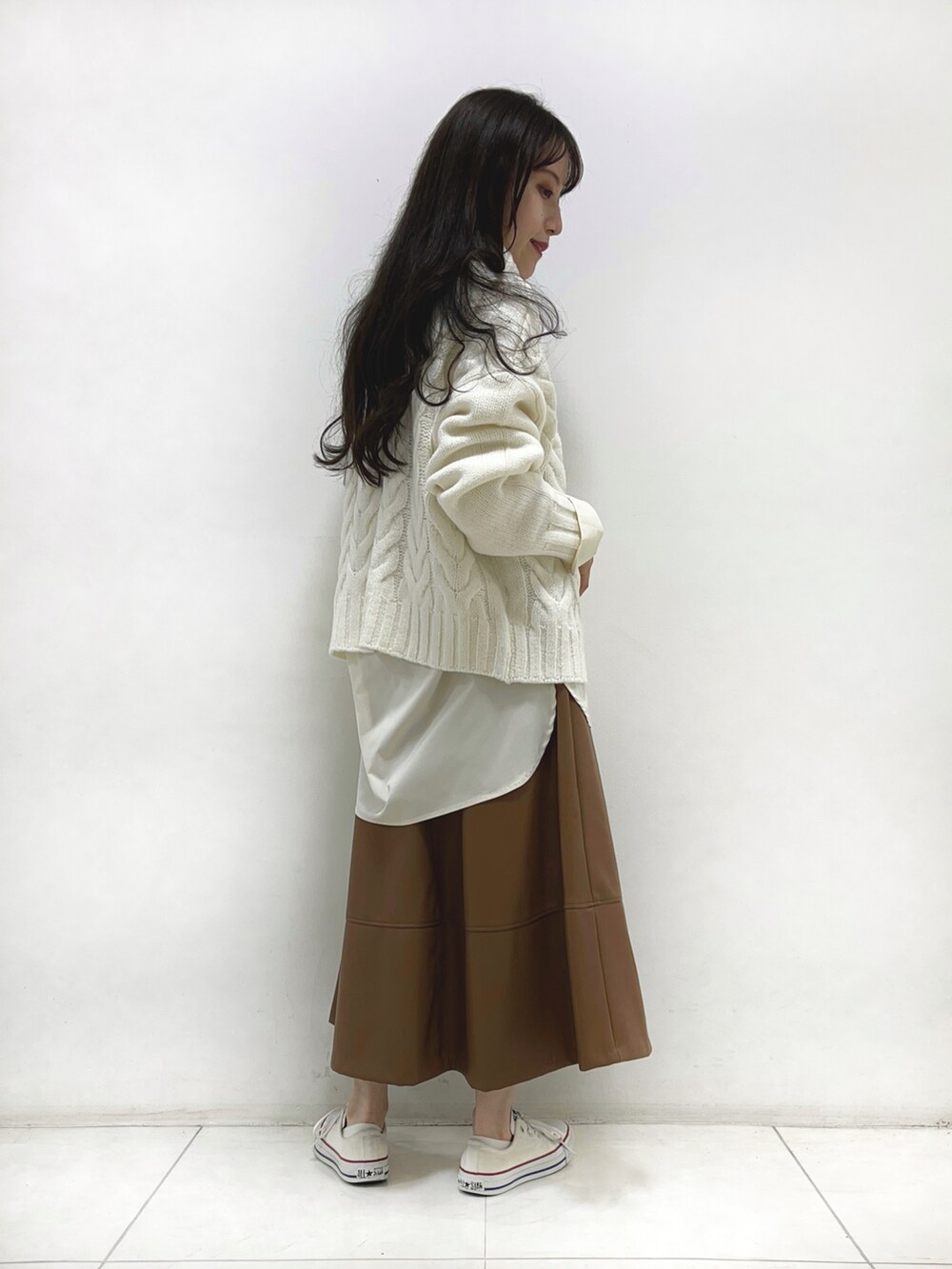 ホワイト系のニット/セーター、ホワイト系のシャツ/ブラウス、イエロー系のスカートを着用したレディースの秋コーディネートの2枚目の写真