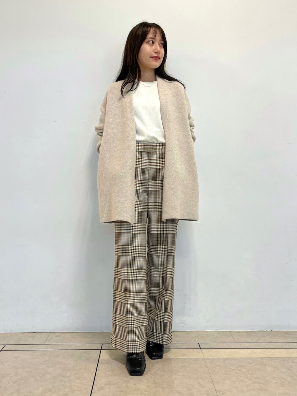 ベージュ系のカーディガン/ボレロ、ホワイト系のニット/セーター、ホワイト系のスニーカーを着用したレディースの秋コーディネートの3枚目の写真