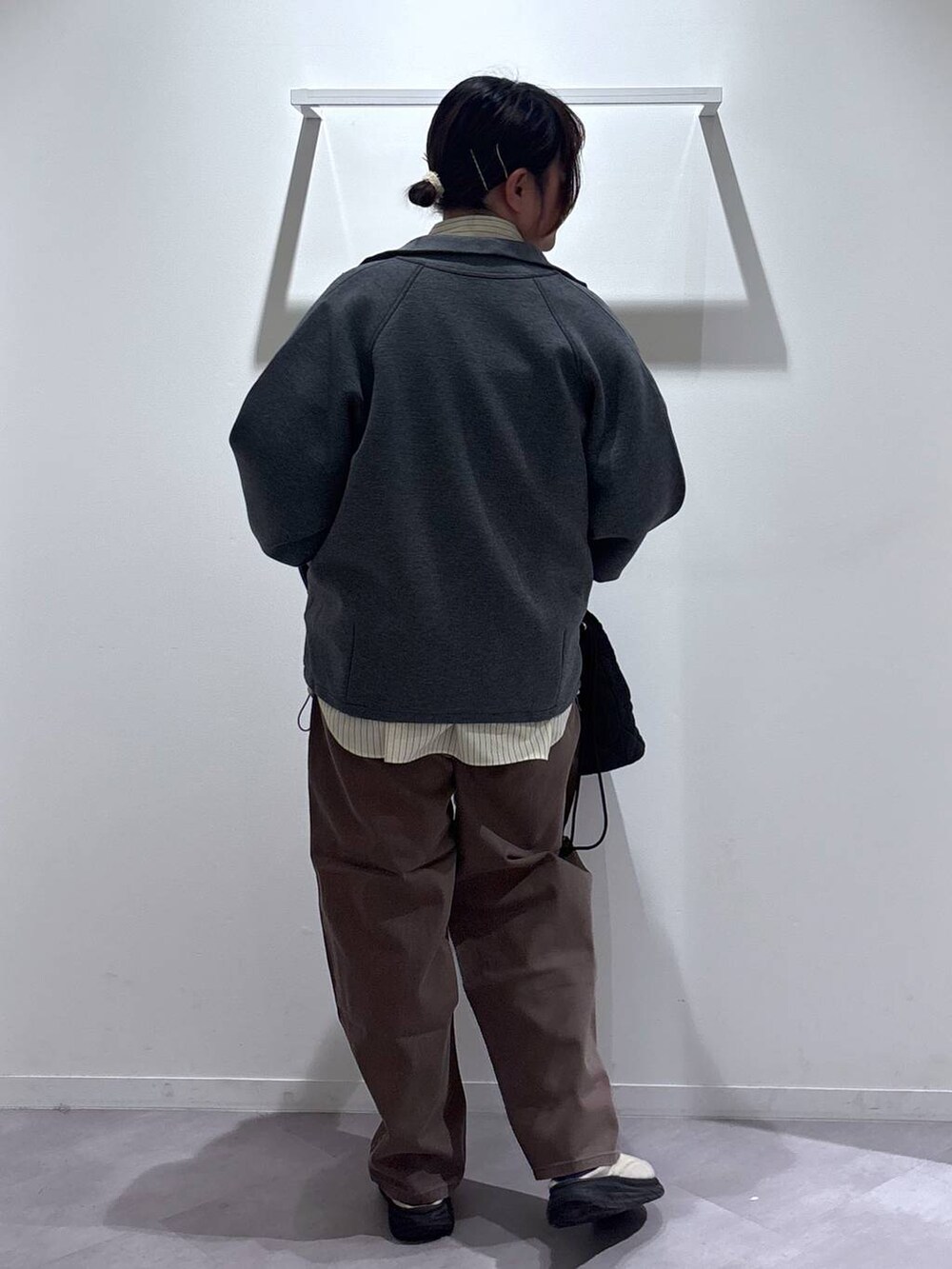 ブラック系のハンドバッグ、ブラウン系のデニムパンツ、ベージュ系のその他シューズを着用したレディースの春コーディネートの3枚目の写真