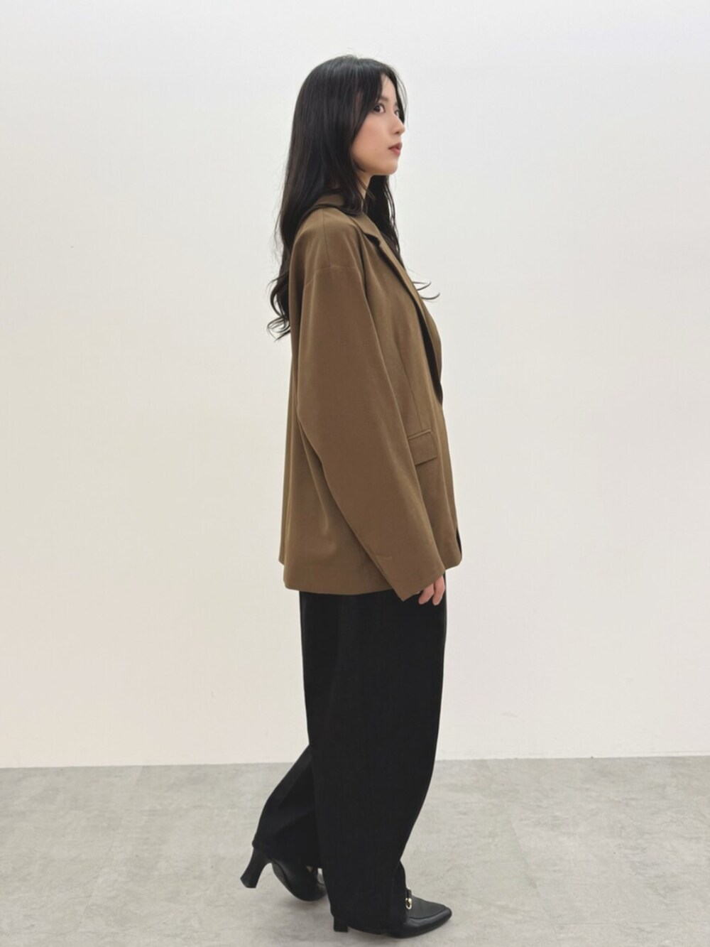 ブラック系のつなぎ/オールインワン、ブラウン系のテーラードジャケットを着用したレディースの春コーディネートの3枚目の写真