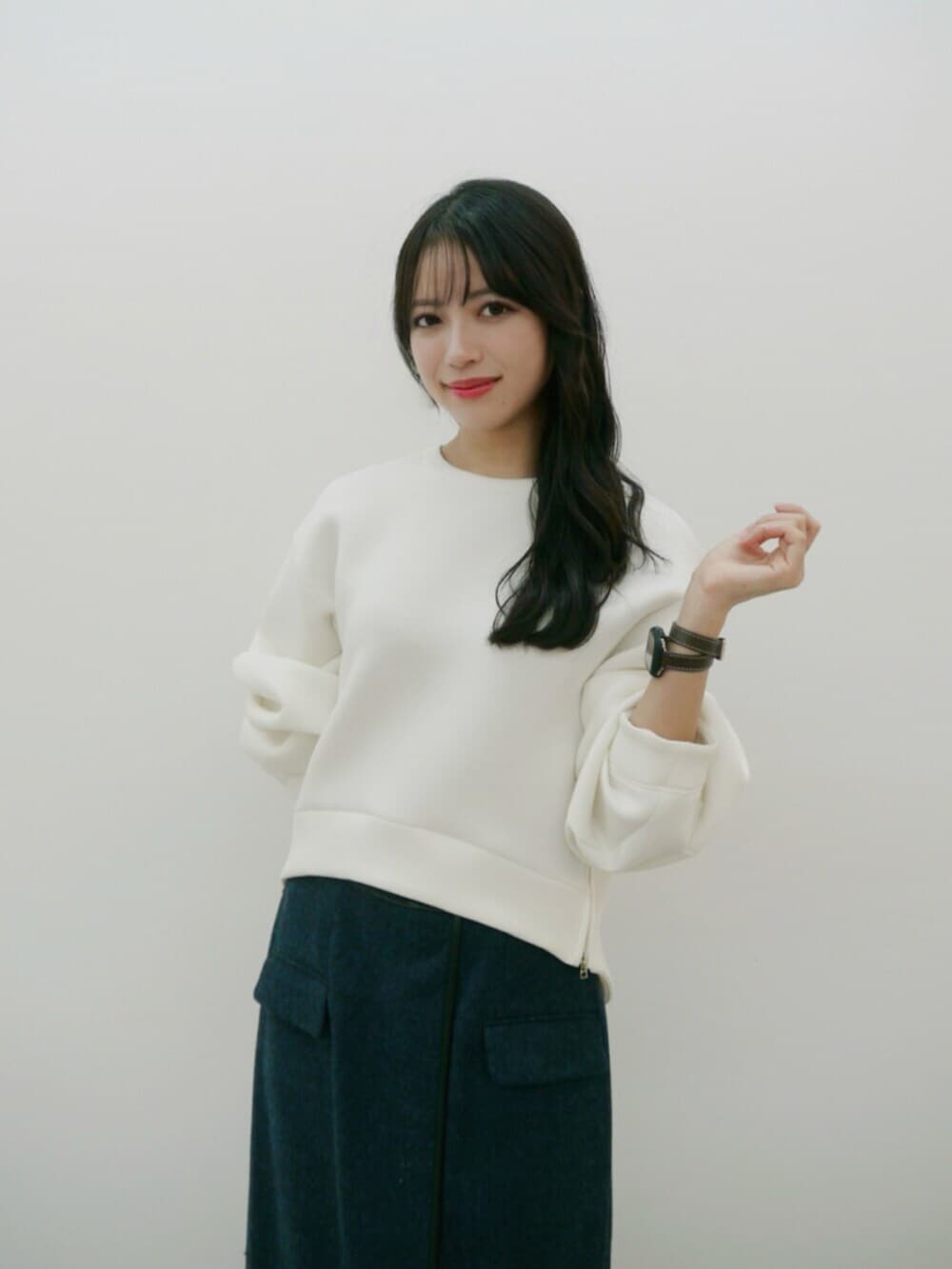 ホワイト系のスウェット、ブルー系のスカート、ブラック系のブーツを着用したレディースの秋コーディネートの4枚目の写真