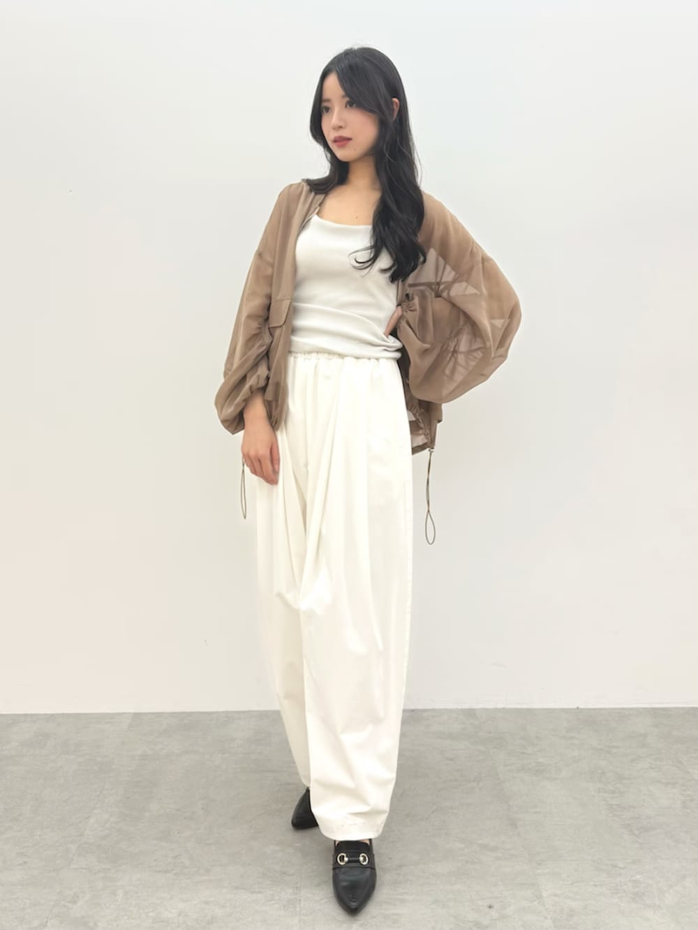 ホワイト系のタンクトップ、ホワイト系のその他パンツ、ベージュ系のブルゾンを着用したレディースの春コーディネートの2枚目の写真