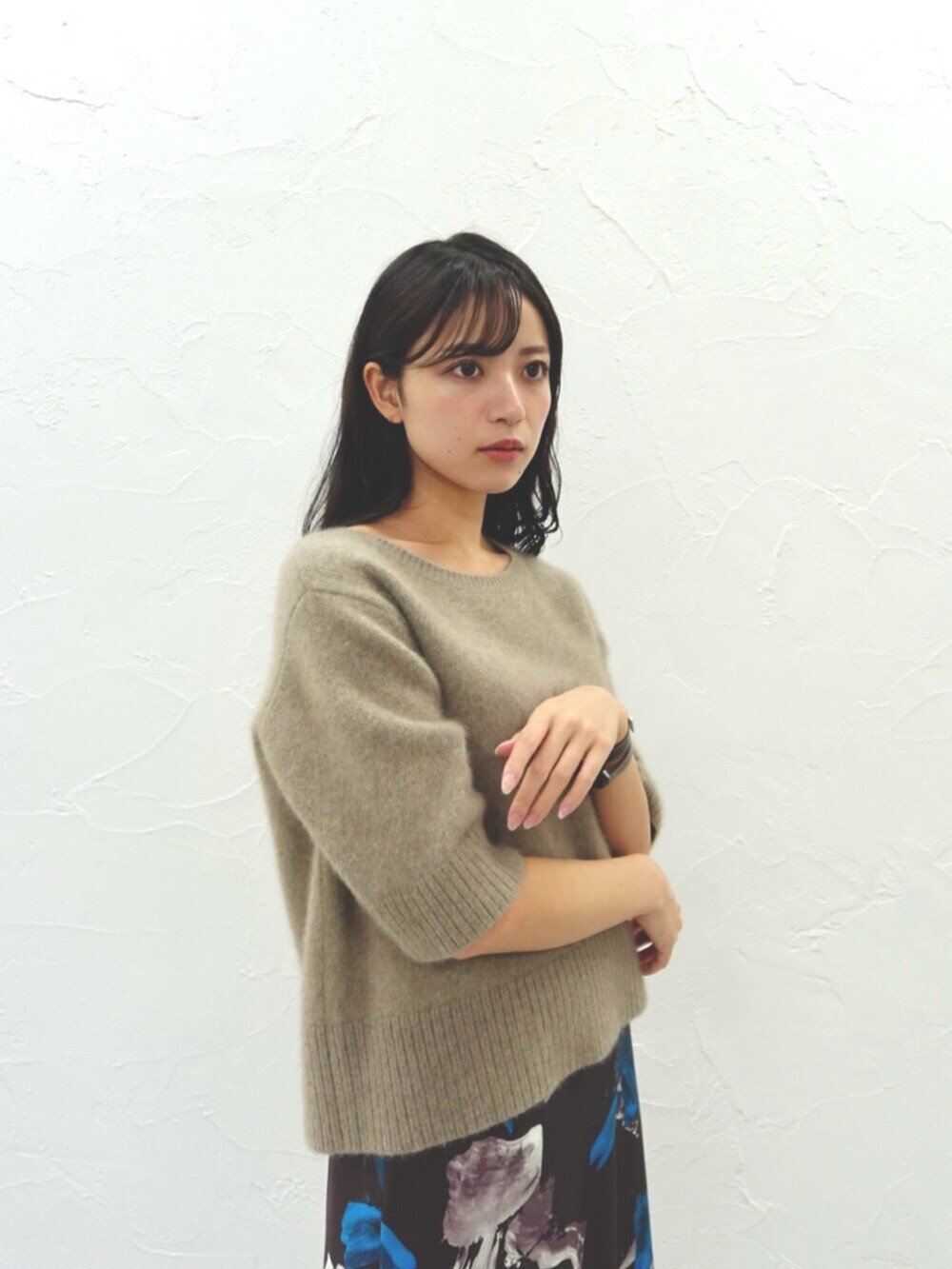 ベージュ系のニット/セーター、ブラウン系のスカートを着用したレディースの秋コーディネートの2枚目の写真