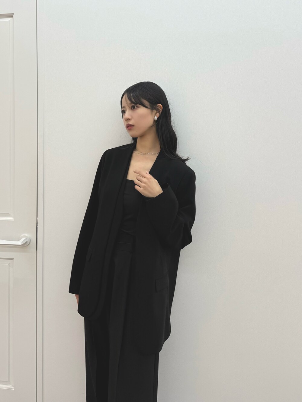 ブラック系のパンプス、ブラック系のノーカラージャケット、ブラック系のキャミソールを着用したレディースの冬コーディネートの5枚目の写真
