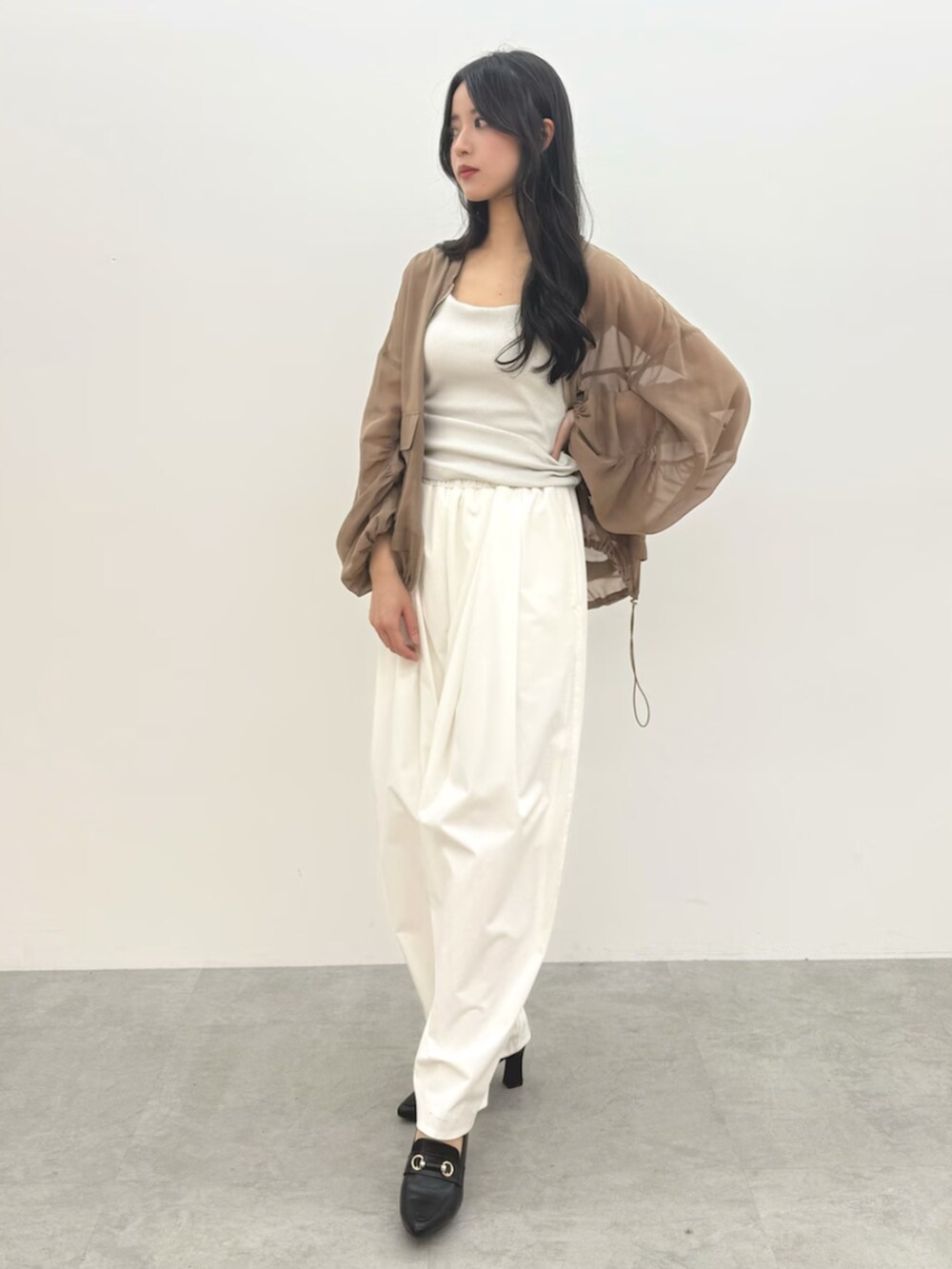 ホワイト系のタンクトップ、ホワイト系のその他パンツ、ベージュ系のブルゾンを着用したレディースの春コーディネートの3枚目の写真