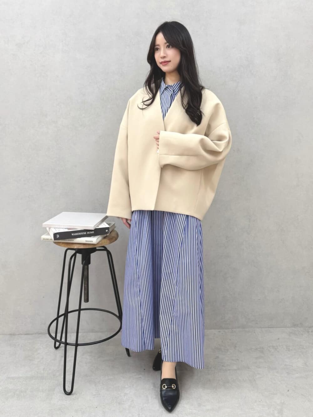 ブルー系のシャツワンピース、ベージュ系のその他アウターを着用したレディースの春コーディネートの2枚目の写真