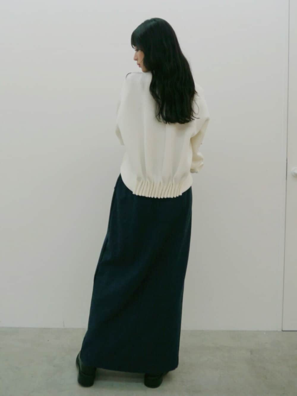 ホワイト系のスウェット、ブルー系のスカート、ブラック系のブーツを着用したレディースの秋コーディネートの3枚目の写真