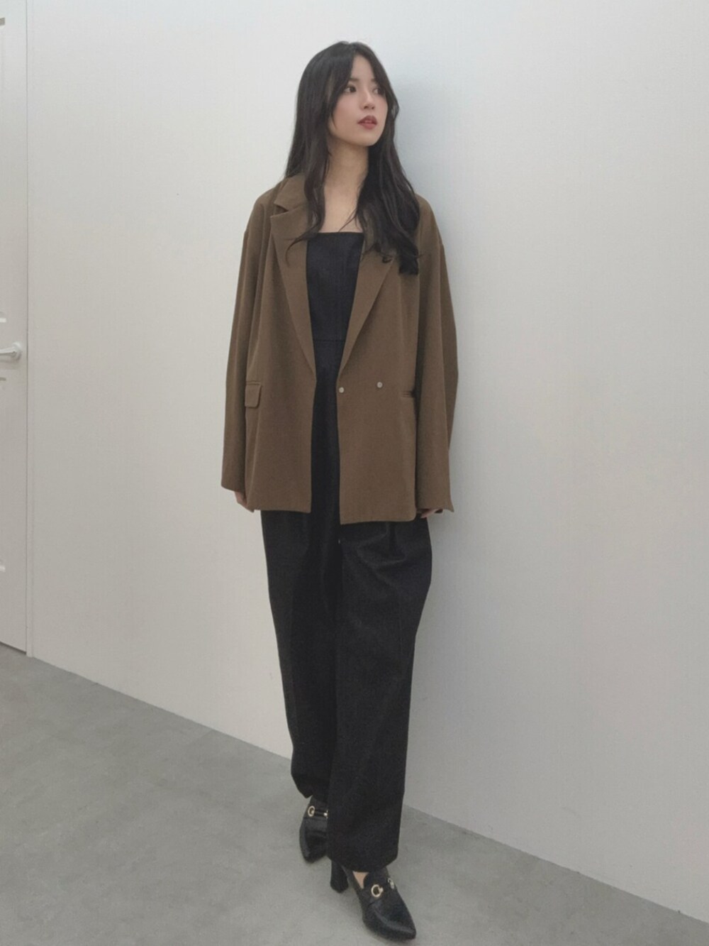 ブラック系のつなぎ/オールインワン、ブラウン系のテーラードジャケットを着用したレディースの春コーディネートの2枚目の写真