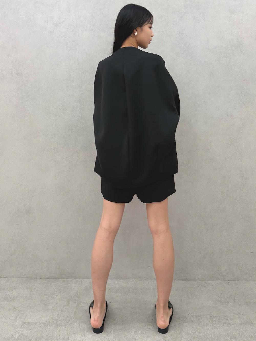 ブラック系のパンプス、ブラック系のノーカラージャケット、ブラック系のその他パンツを着用したレディースの冬コーディネートの3枚目の写真