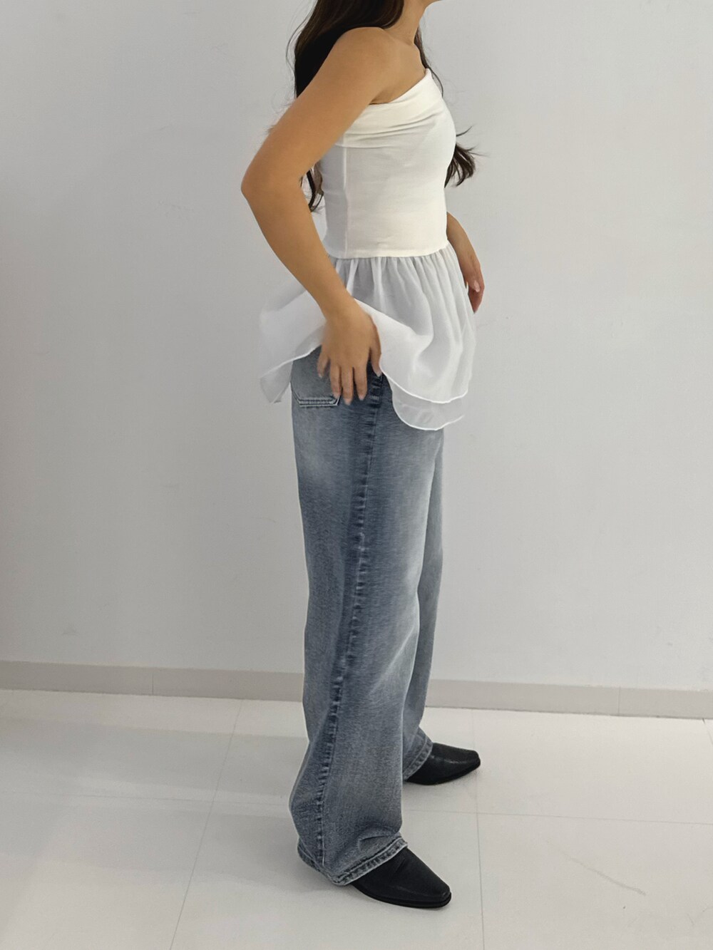 ホワイト系のトップス、グレー系のデニムパンツ、ブラック系のローファーを着用したレディースの春コーディネートの2枚目の写真