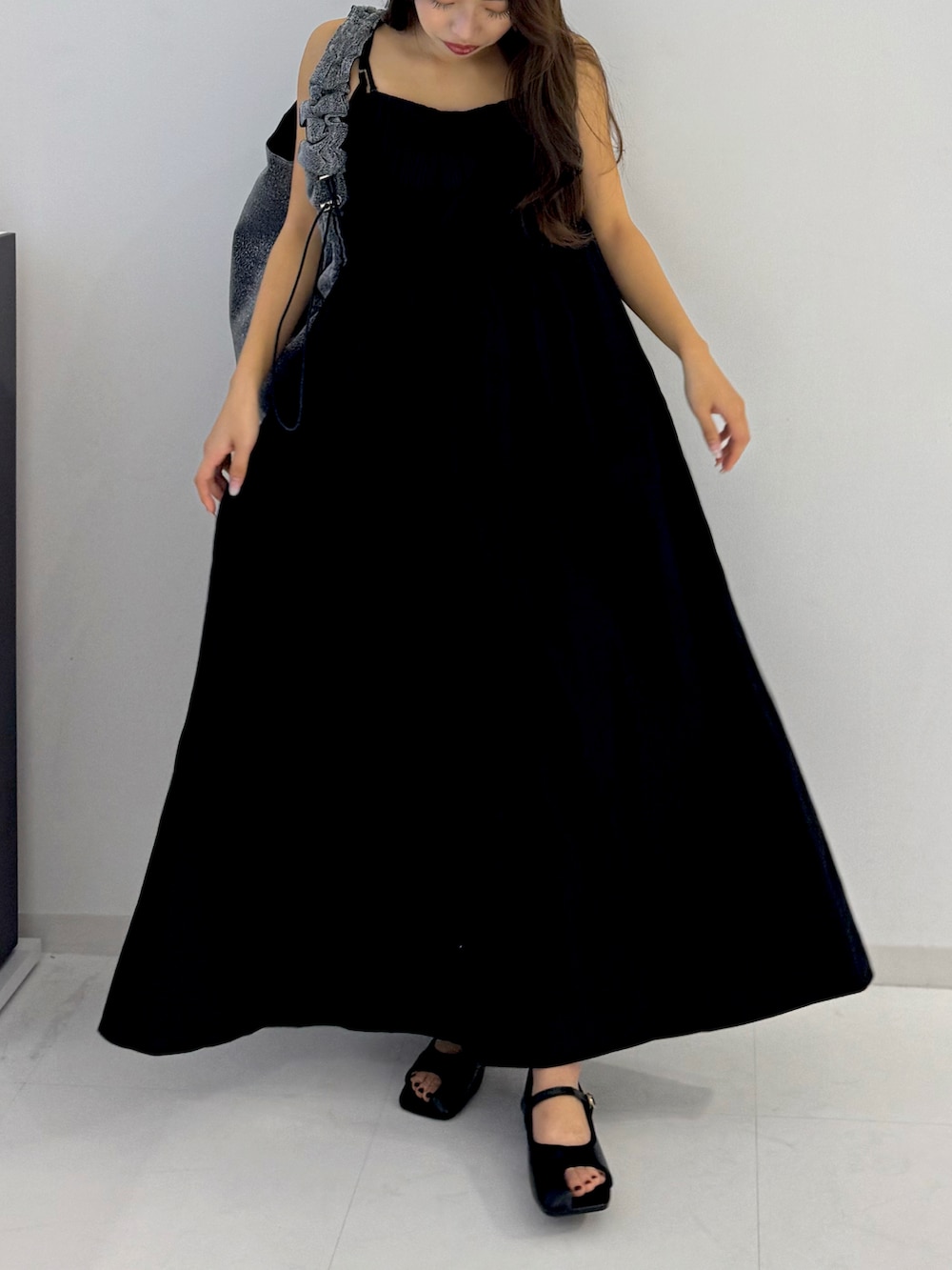 ブラック系のパンプス、シルバー系のトートバッグを着用したレディースの春コーディネートの3枚目の写真