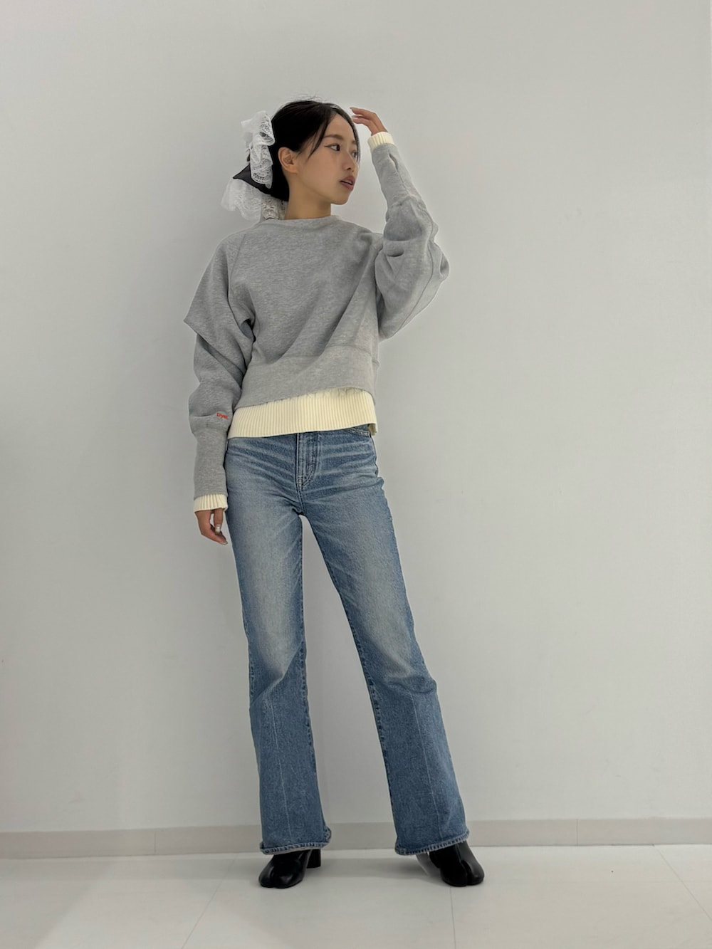 グレー系のスウェット、ブラック系のブーツ、ベージュ系のトップスを着用したレディースの秋コーディネートの3枚目の写真