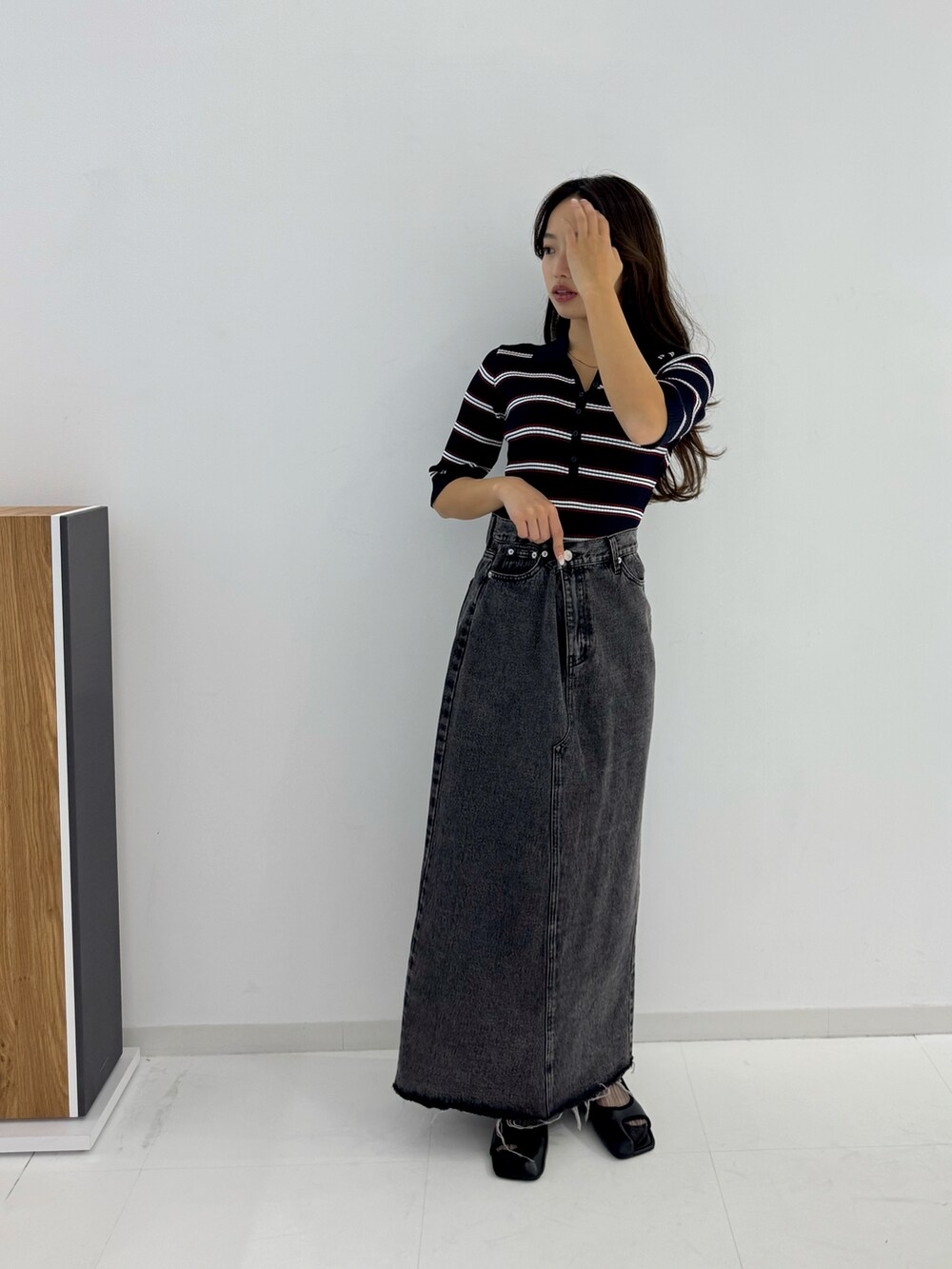 ブラック系のデニムスカート、ブラック系のパンプスを着用したレディースの春コーディネートの4枚目の写真