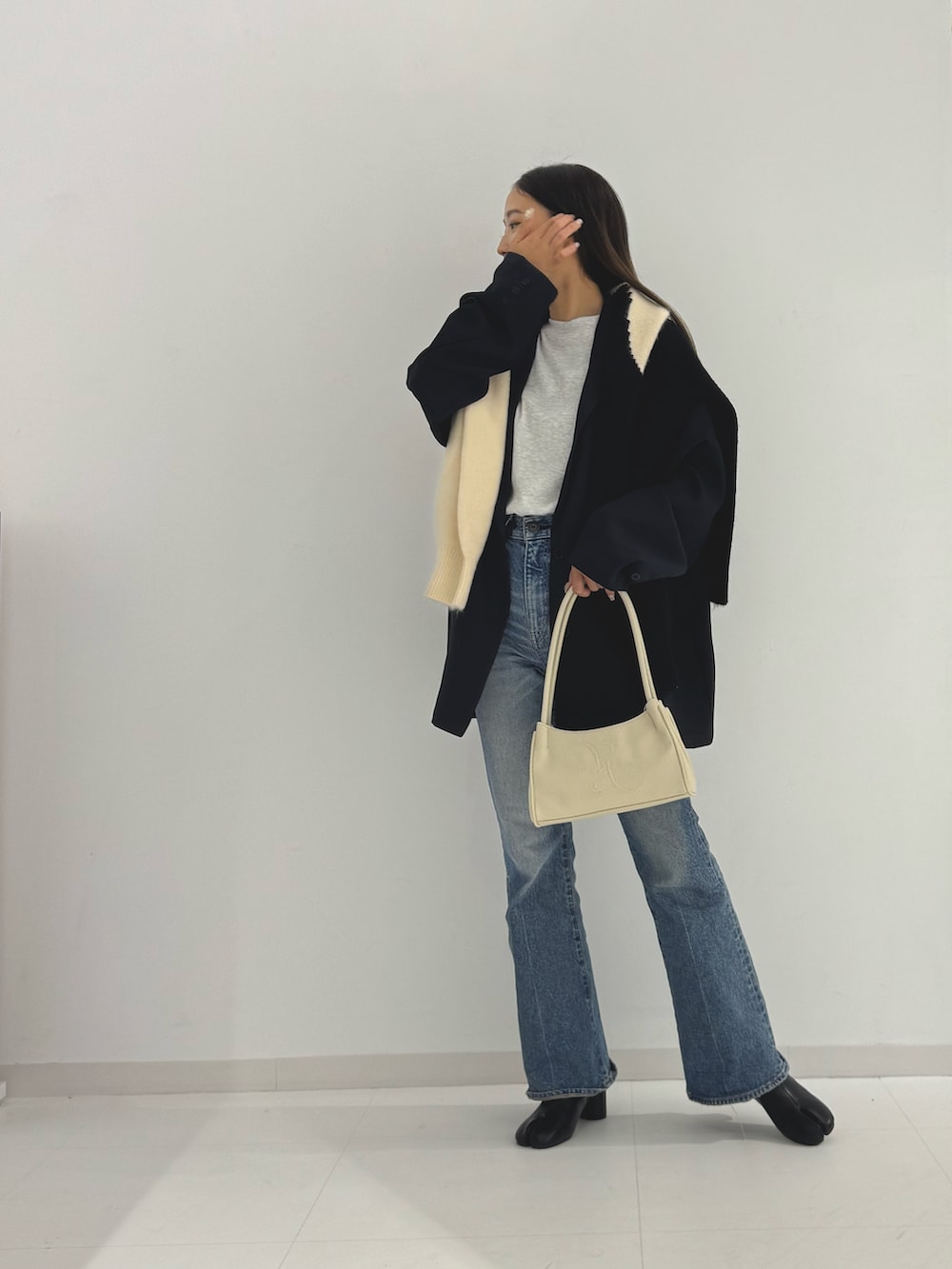 ブラック系のブーツ、ベージュ系のトートバッグ、ブラック系のテーラードジャケットを着用したレディースの秋コーディネートの2枚目の写真