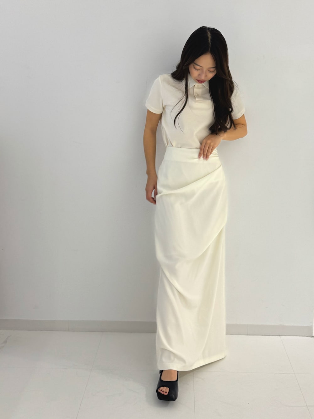 ホワイト系のスカート、ブラック系のサンダル、ホワイト系のポロシャツを着用したレディースの春コーディネートの4枚目の写真