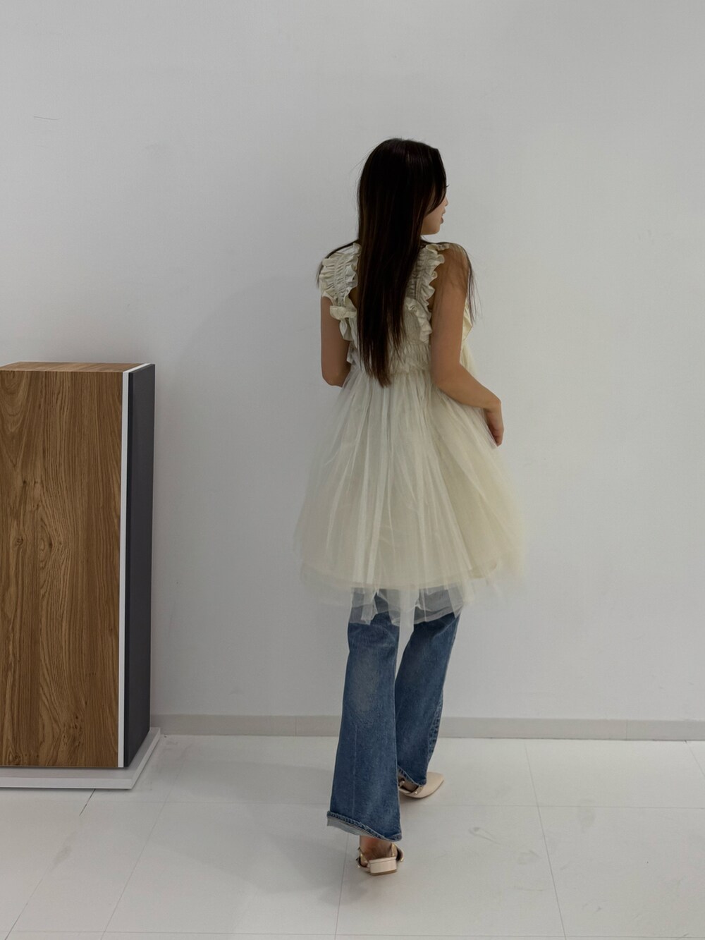 ベージュ系のキャミソールを着用したレディースの夏コーディネートの2枚目の写真