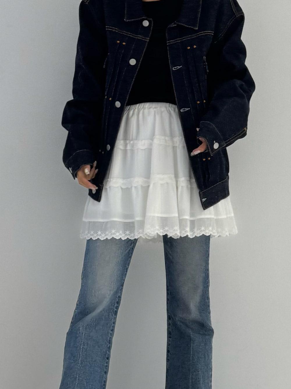 ブラック系のTシャツ/カットソー、ホワイト系のスカート、ブラック系のブーツを着用したレディースの秋コーディネートの3枚目の写真