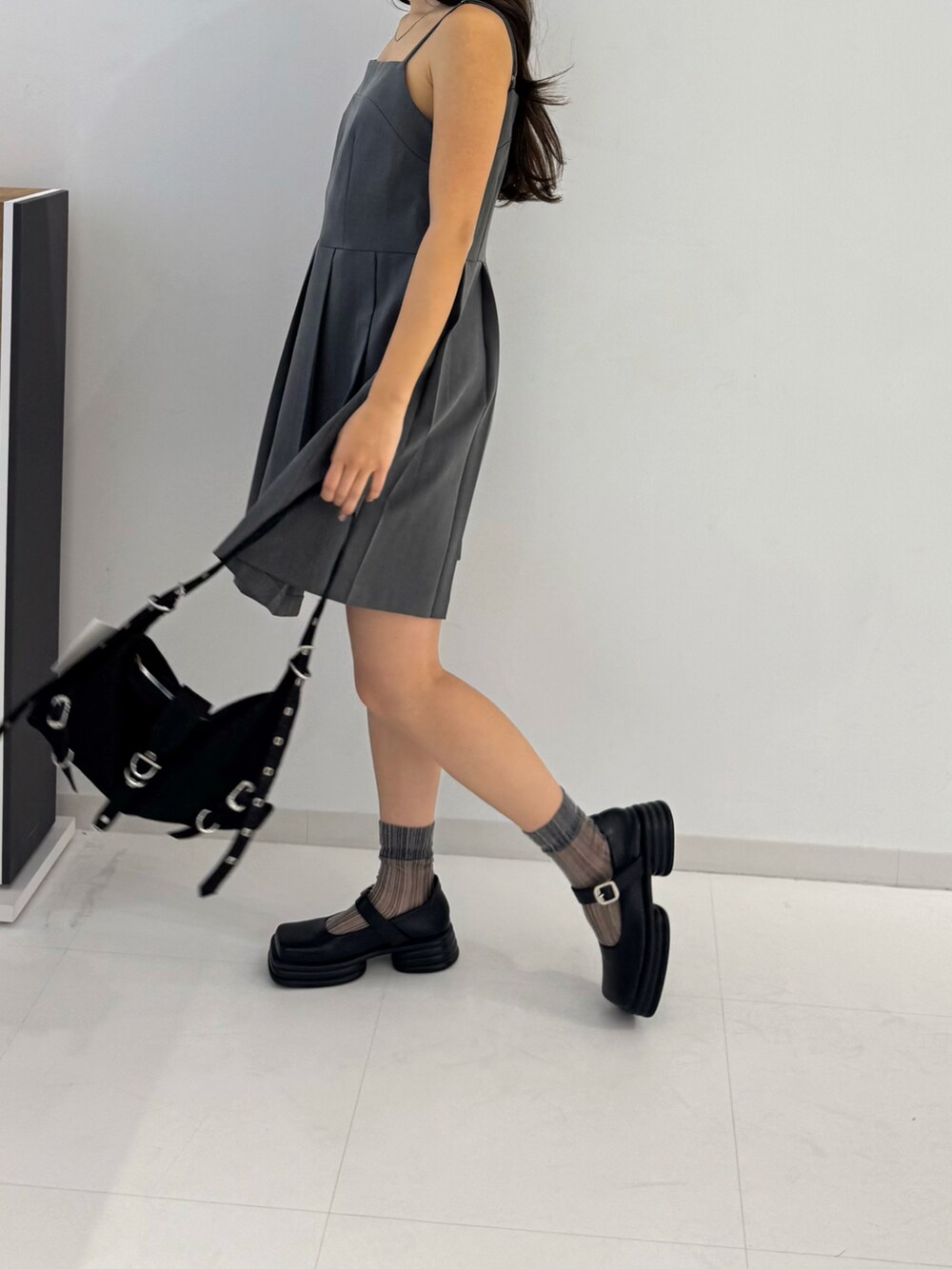 グレー系のワンピース、ブラック系のローファー、ブラック系のトートバッグを着用したレディースの春コーディネートの2枚目の写真