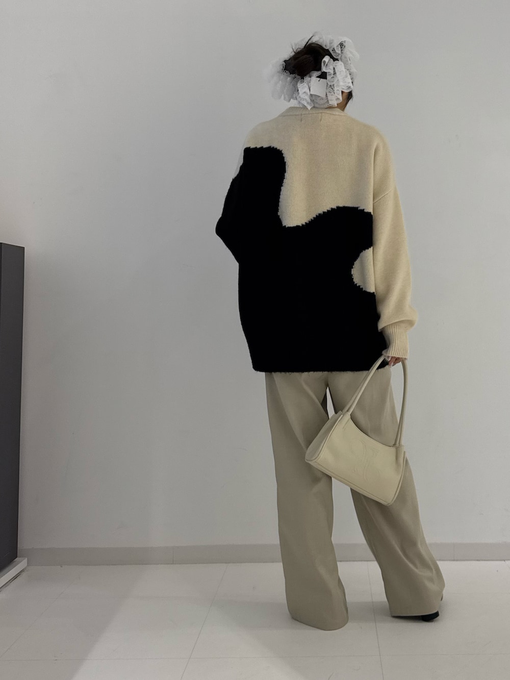 ベージュ系のスラックス、ブラック系のブーツ、ベージュ系のニット/セーターを着用したレディースの秋コーディネートの3枚目の写真