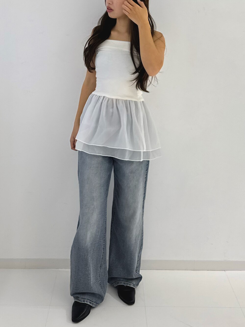 ホワイト系のトップス、グレー系のデニムパンツ、ブラック系のローファーを着用したレディースの春コーディネートの4枚目の写真