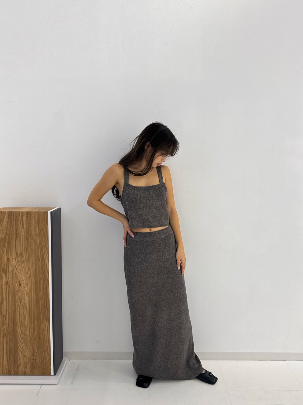 グレー系のトップス、グレー系のスカート、ブラック系のサンダルを着用したレディースの春コーディネートの4枚目の写真