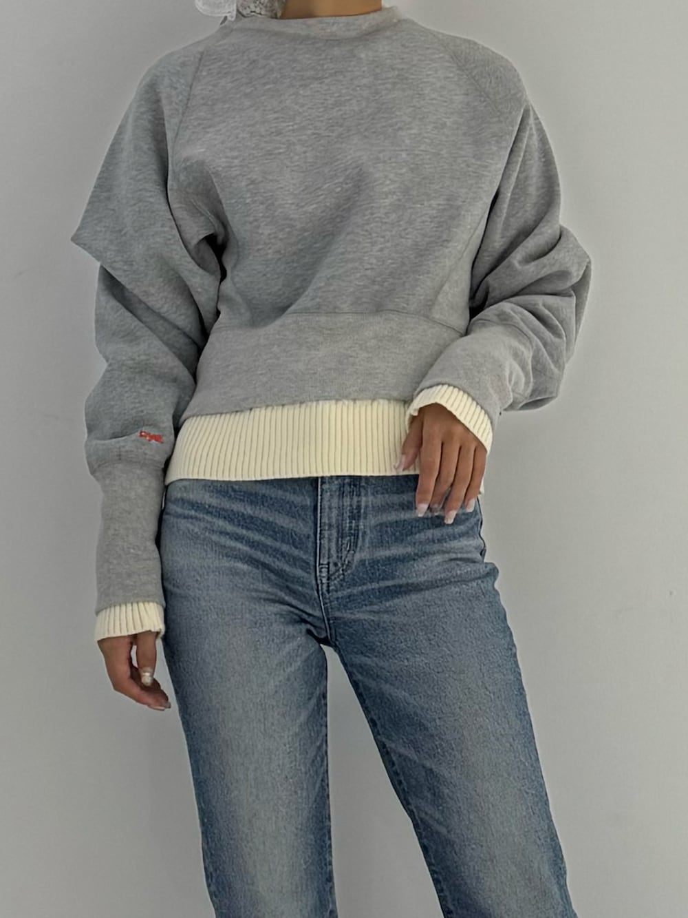 グレー系のスウェット、ブラック系のブーツ、ベージュ系のトップスを着用したレディースの秋コーディネートの4枚目の写真