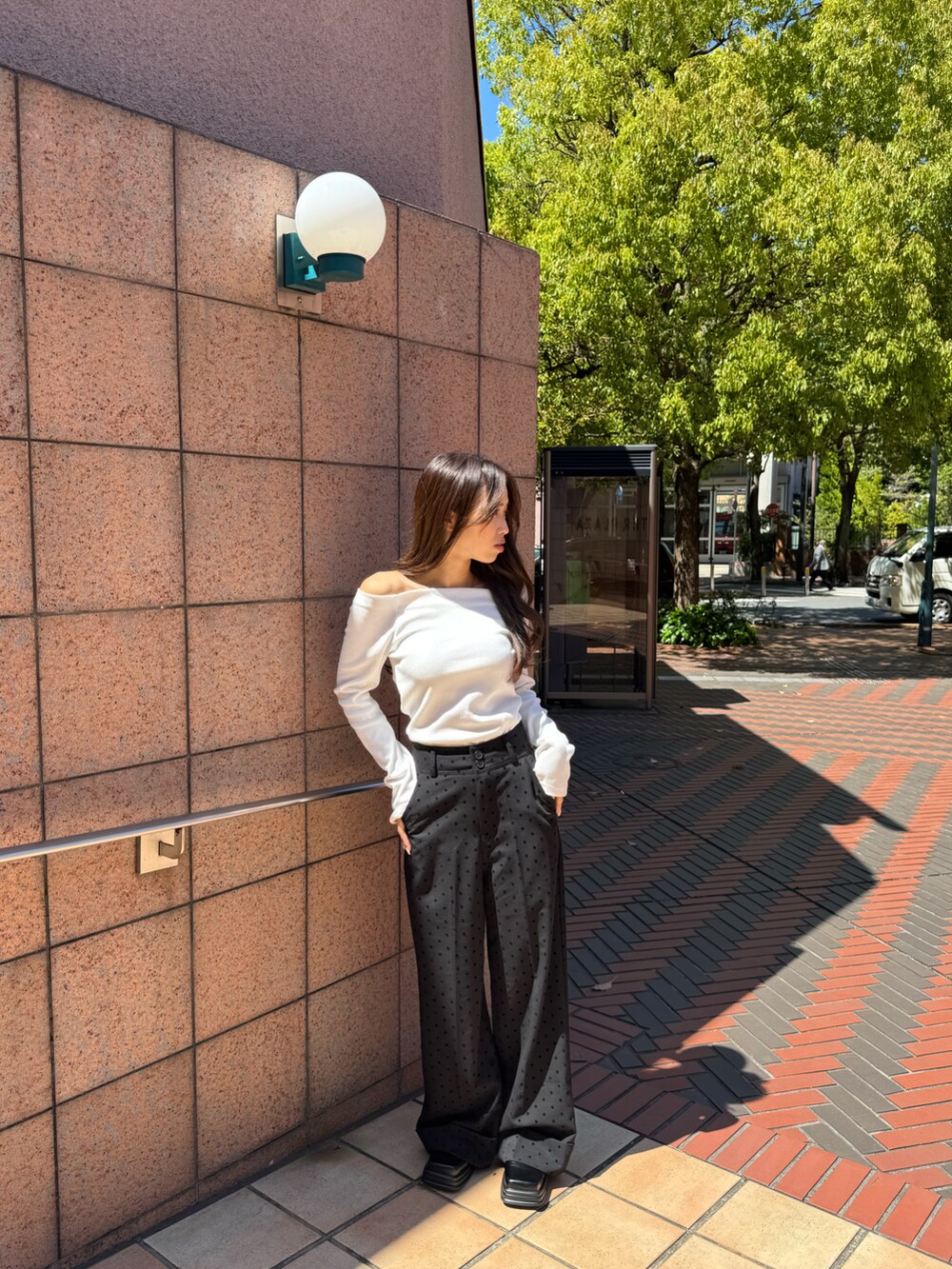 ホワイト系のトップス、ブラック系のスラックスを着用したレディースの春コーディネートの4枚目の写真