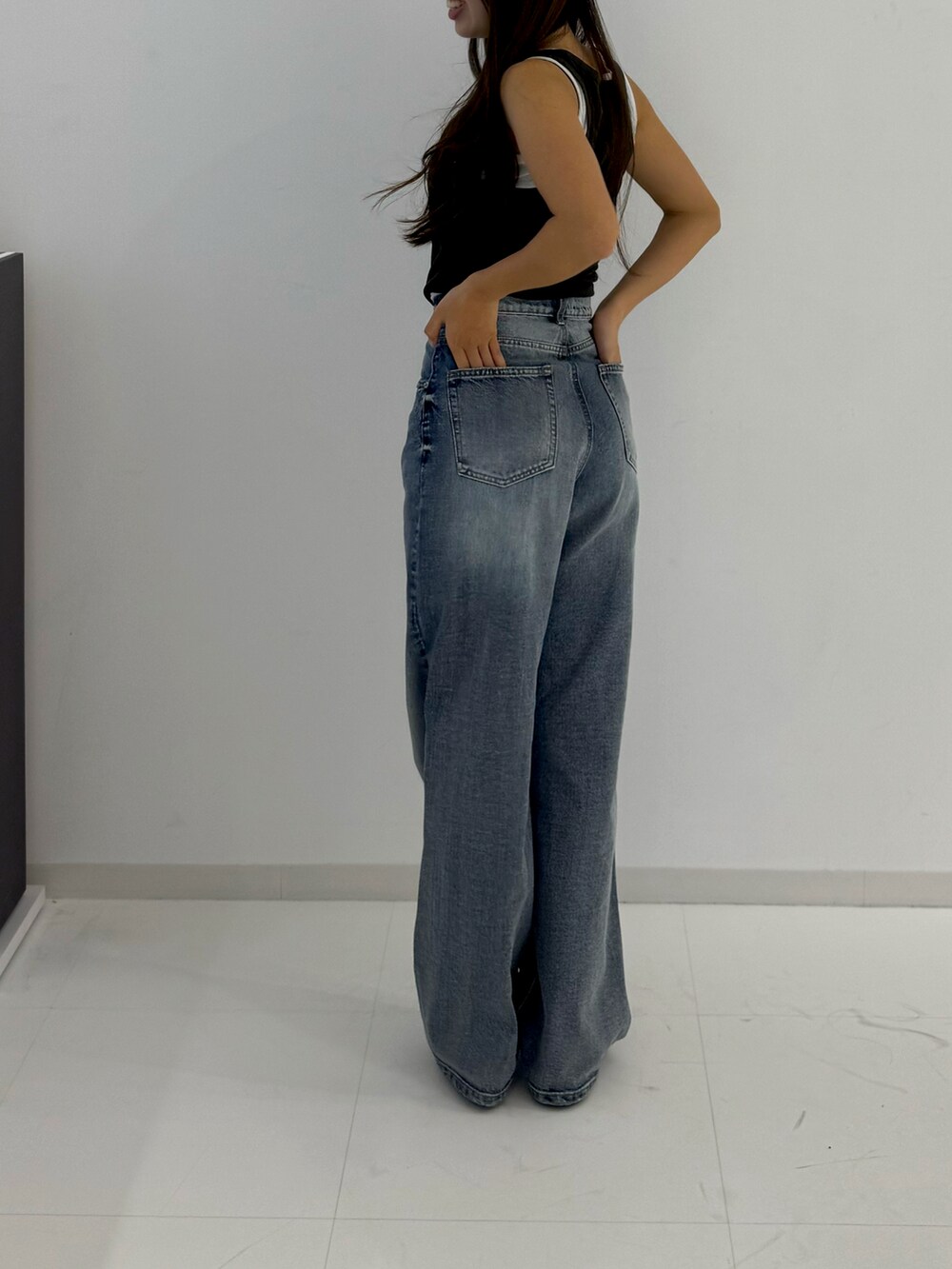 ブラック系のローファー、その他のデニムパンツ、グリーン系のタンクトップを着用したレディースの春コーディネートの3枚目の写真