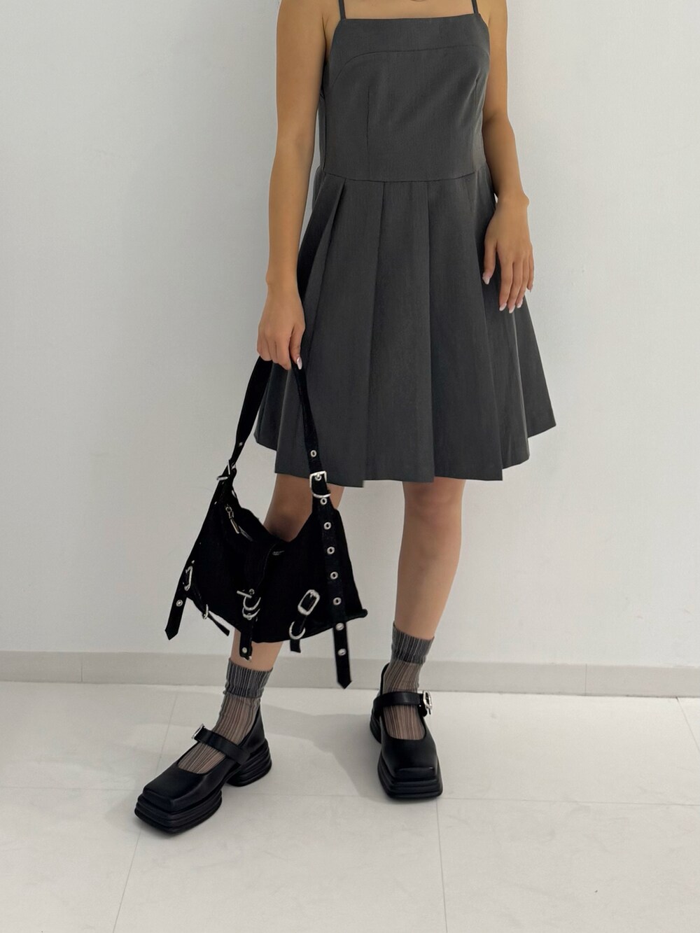 グレー系のワンピース、ブラック系のローファー、ブラック系のトートバッグを着用したレディースの春コーディネートの3枚目の写真