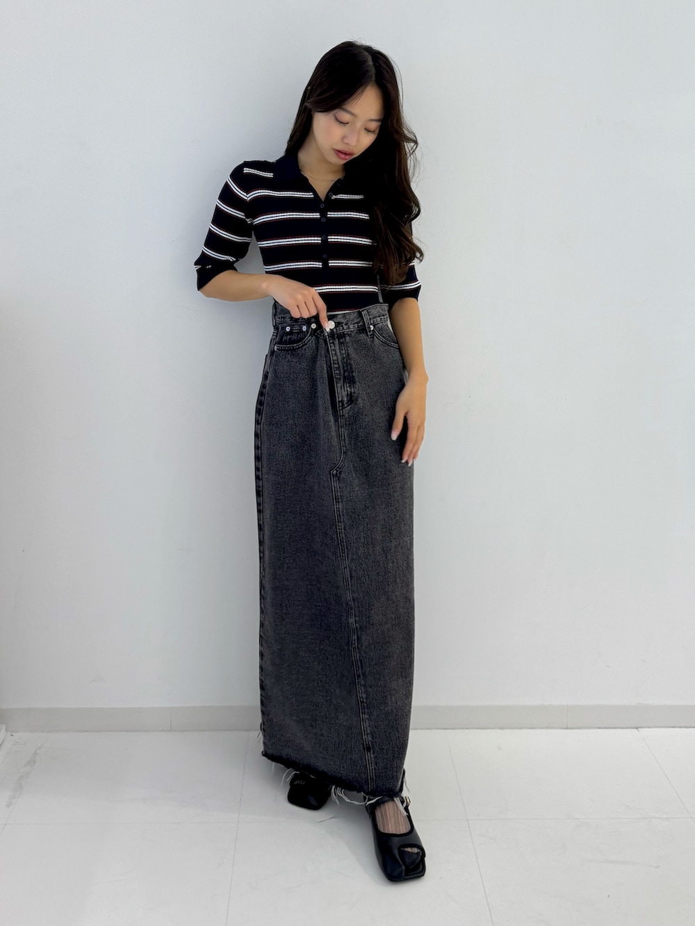 ブラック系のデニムスカート、ブラック系のパンプスを着用したレディースの春コーディネートの5枚目の写真