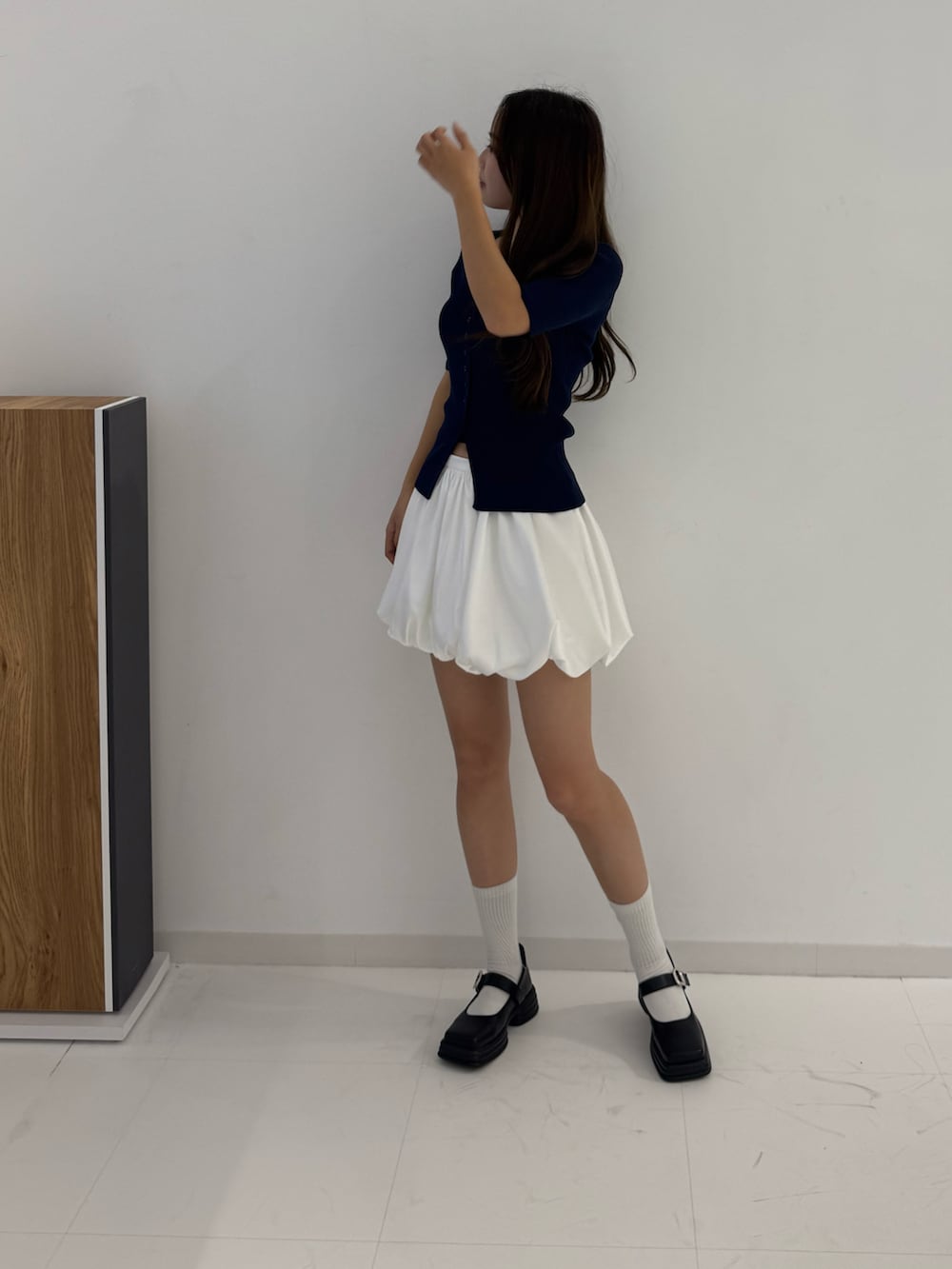 ブルー系のニット/セーター、ホワイト系のスカート、ブラック系のローファーを着用したレディースの春コーディネートの3枚目の写真