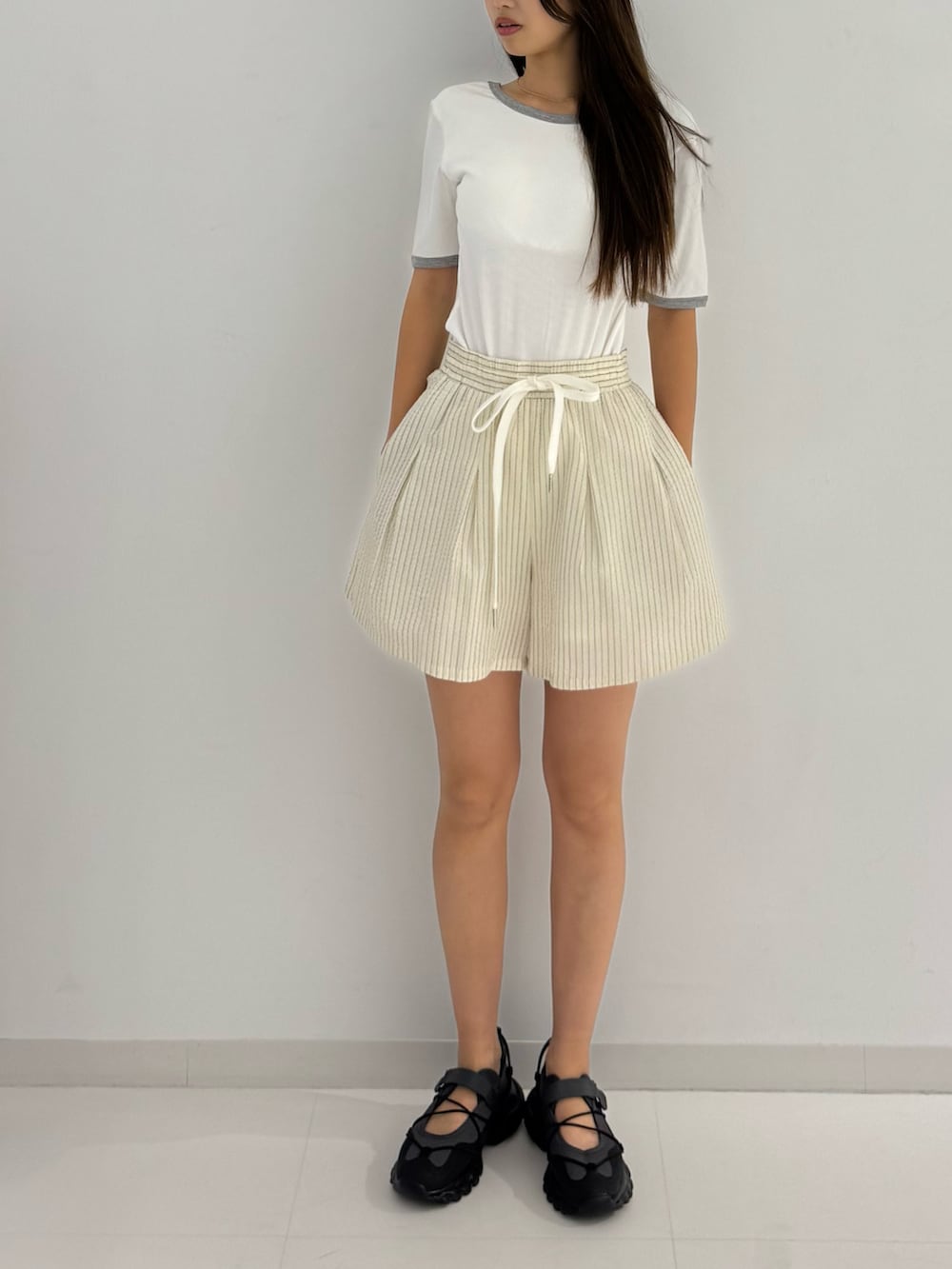 ホワイト系のTシャツ/カットソー、ベージュ系のその他パンツ、ブラック系のシューズを着用したレディースの夏コーディネートの3枚目の写真