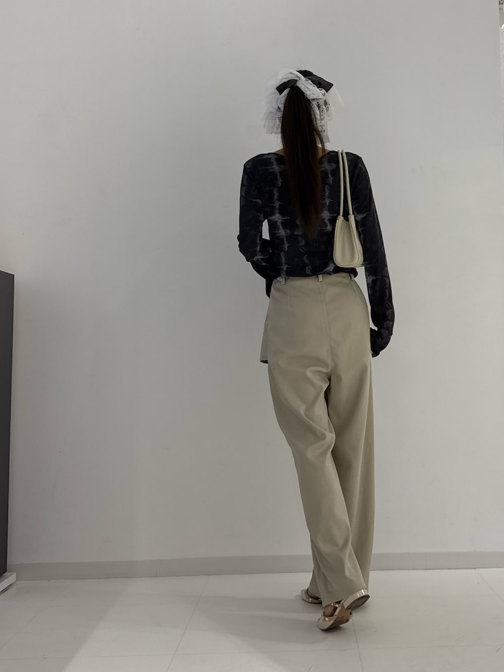 ベージュ系のスラックス、ブラック系のトップス、ベージュ系のトートバッグを着用したレディースの秋コーディネートの3枚目の写真