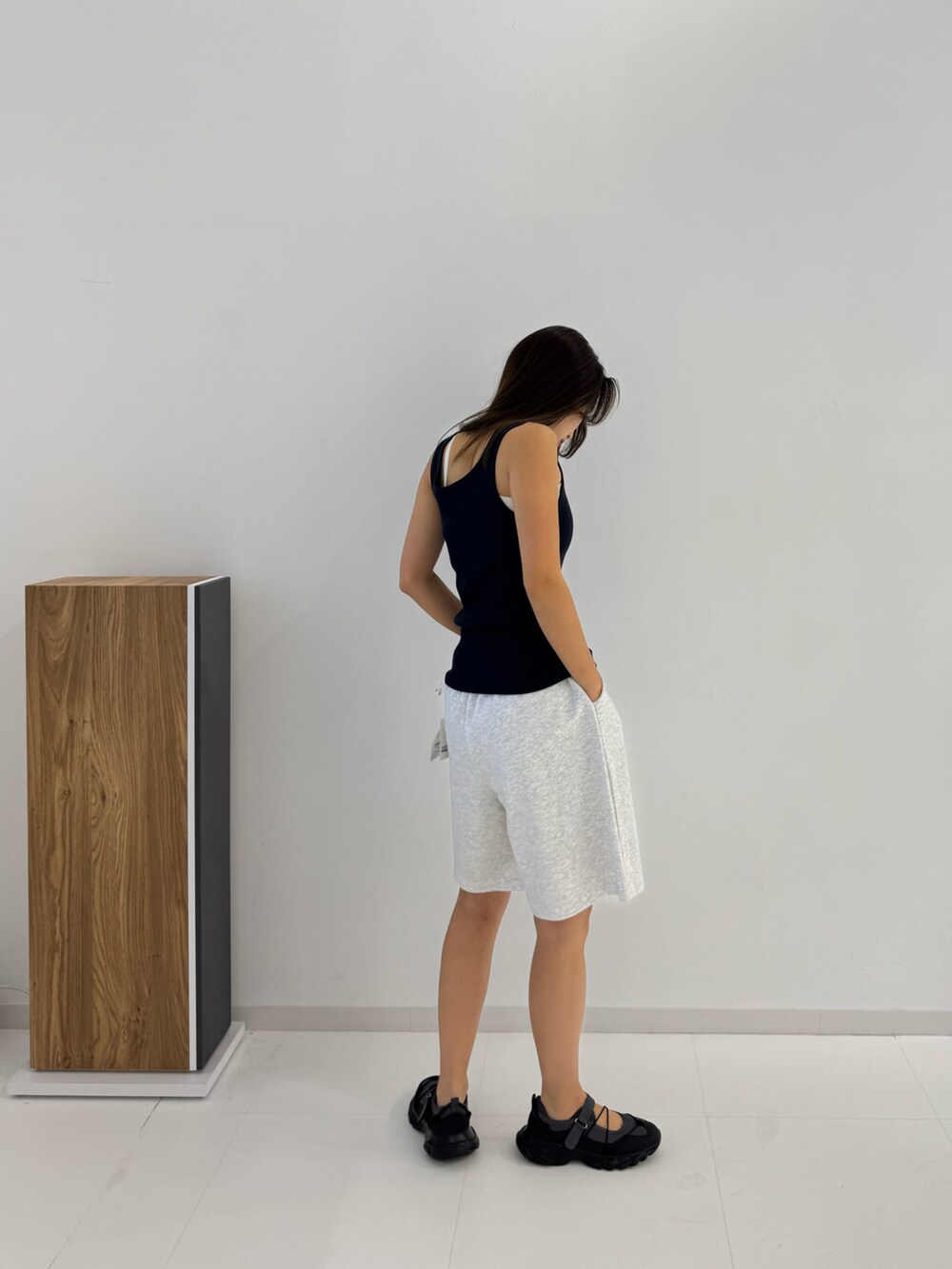 グレー系のスウェットパンツ、ブルー系のタンクトップ、ブラック系のシューズを着用したレディースの夏コーディネートの2枚目の写真