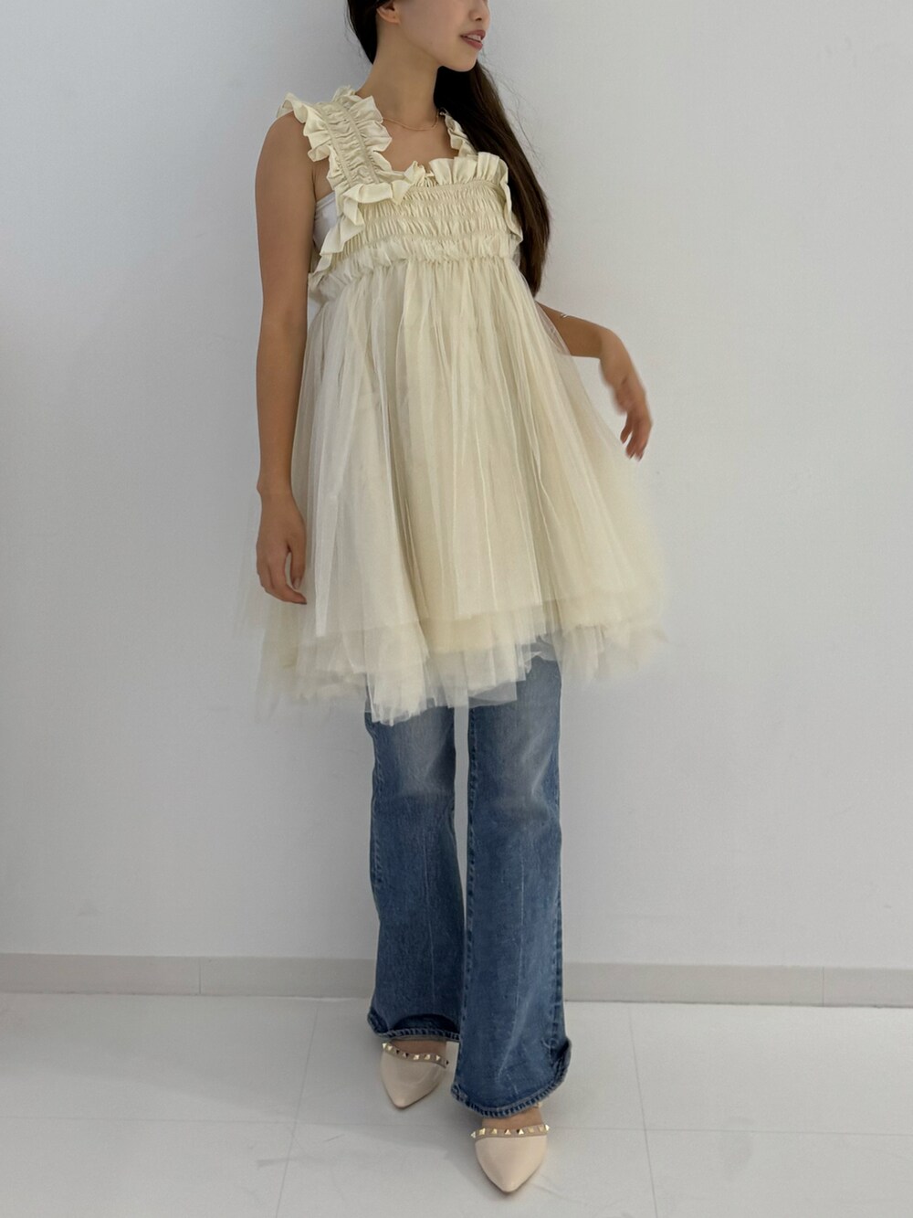 ベージュ系のキャミソールを着用したレディースの夏コーディネートの3枚目の写真