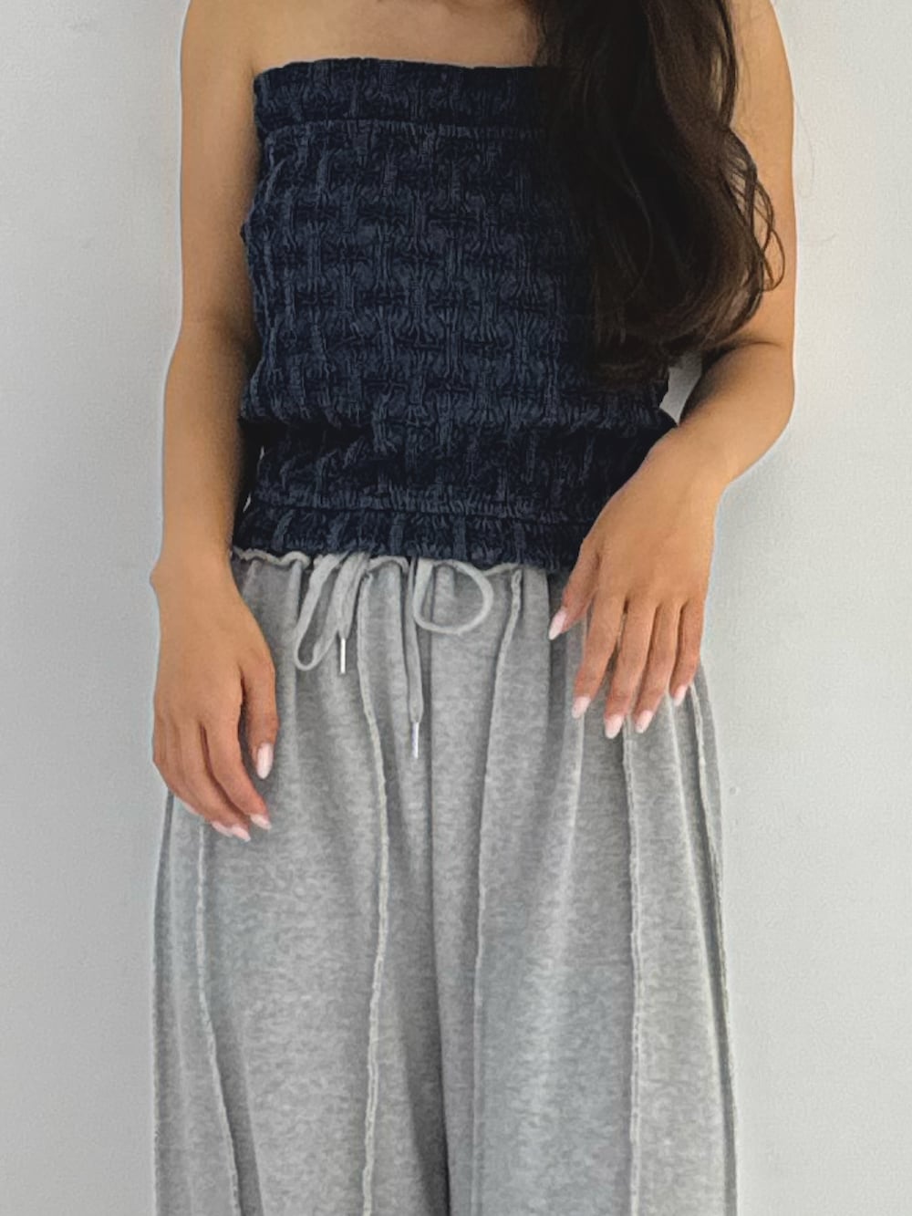 ブルー系のチューブトップ、グレー系のスウェットパンツ、ブラック系のパンプスを着用したレディースの夏コーディネートの2枚目の写真