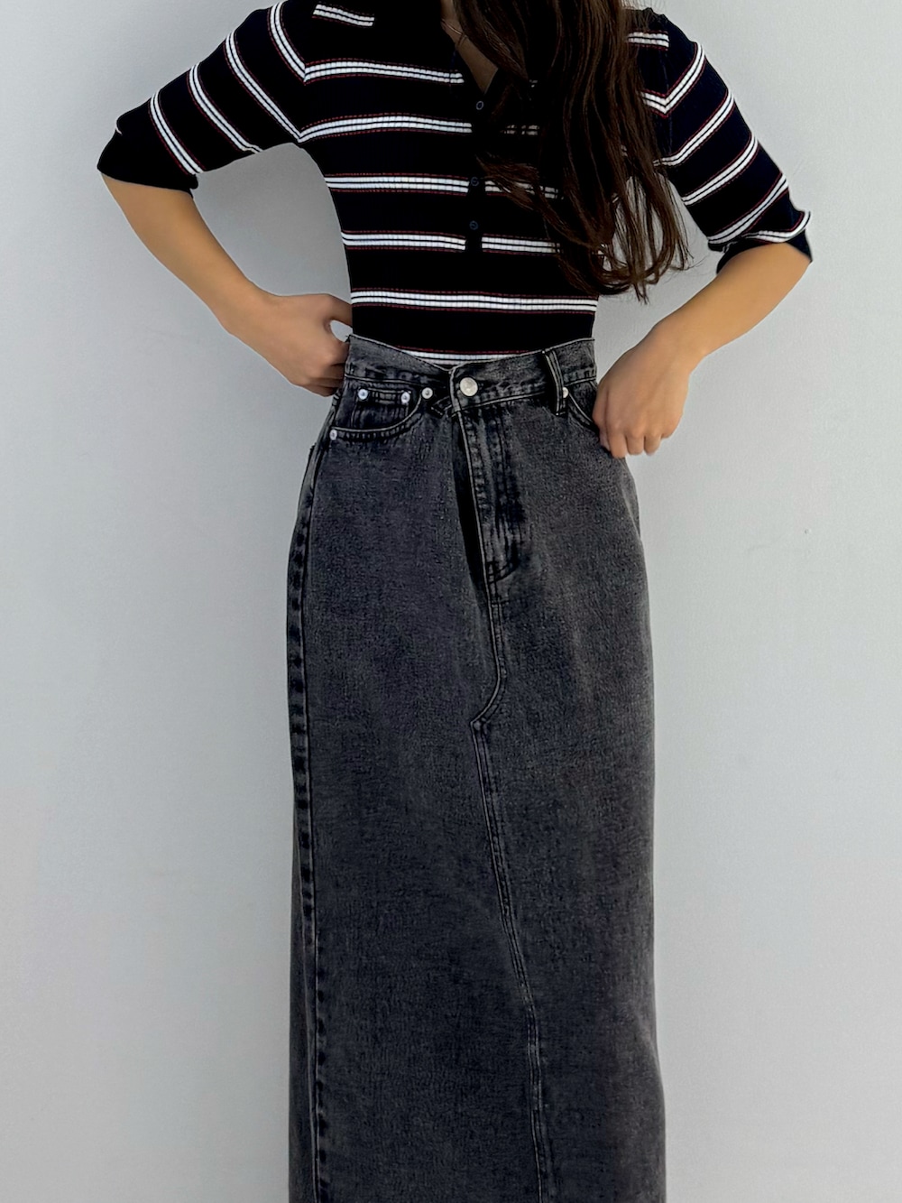 ブラック系のデニムスカート、ブラック系のパンプスを着用したレディースの春コーディネートの3枚目の写真