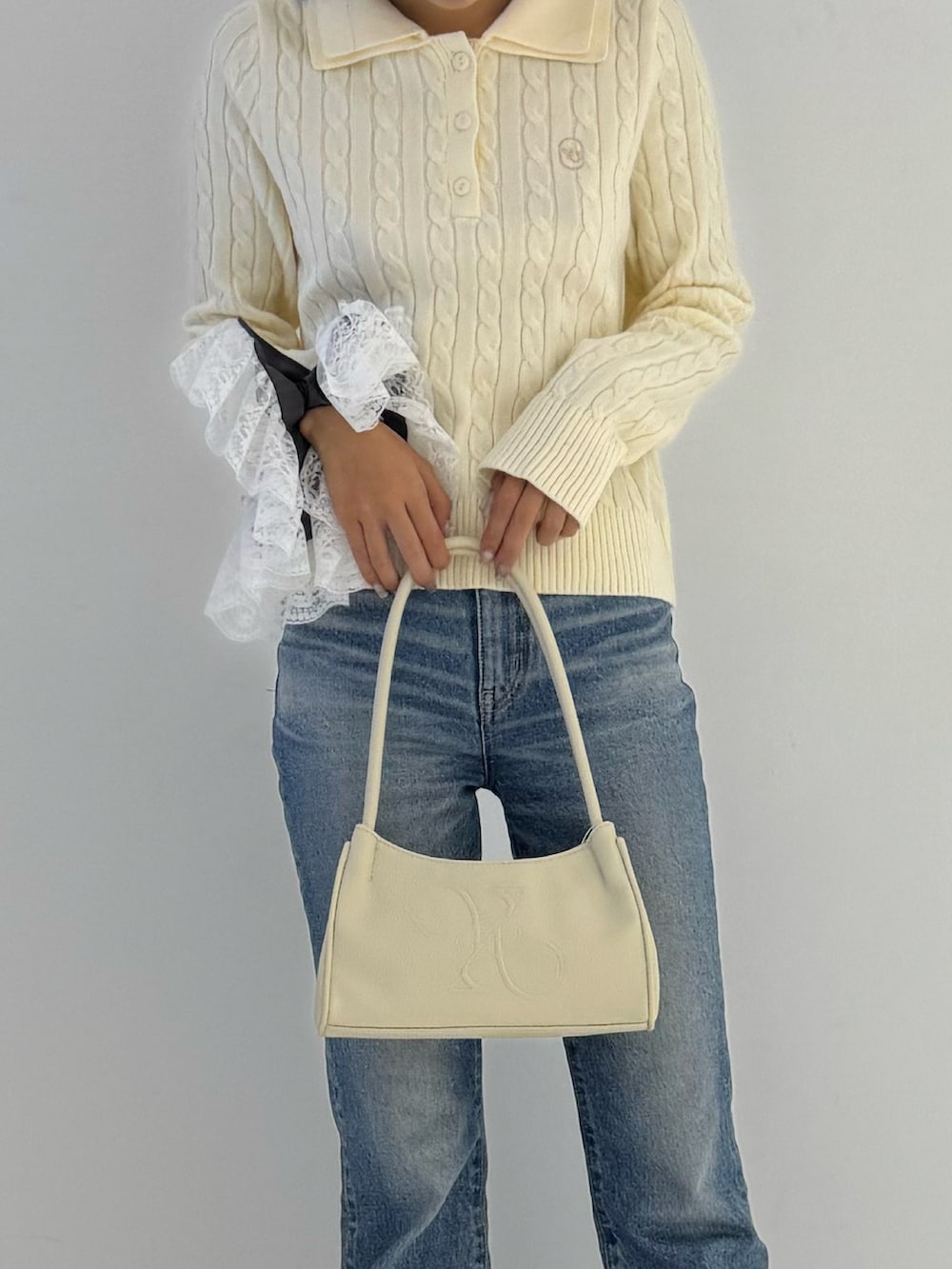 ブラック系のブーツ、ベージュ系のトップス、ベージュ系のトートバッグを着用したレディースの秋コーディネートの2枚目の写真