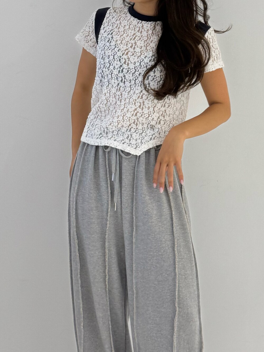 ブラック系のスウェットパンツ、ブラック系のパンプス、ホワイト系のTシャツ/カットソーを着用したレディースの夏コーディネートの2枚目の写真