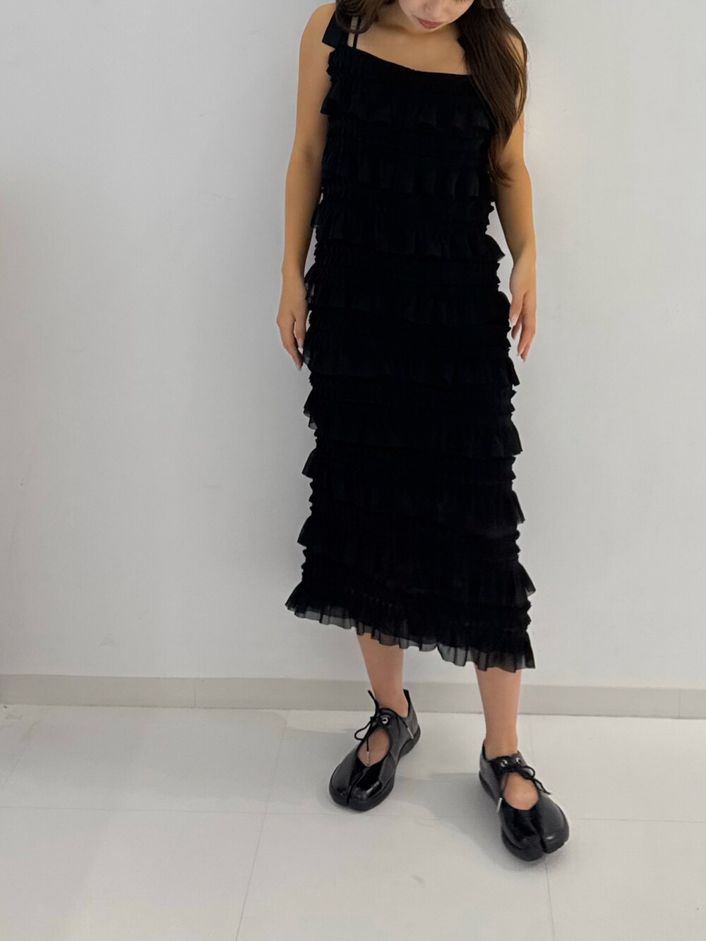 ブラック系のスニーカー、ブラック系のワンピースを着用したレディースの春コーディネートの3枚目の写真