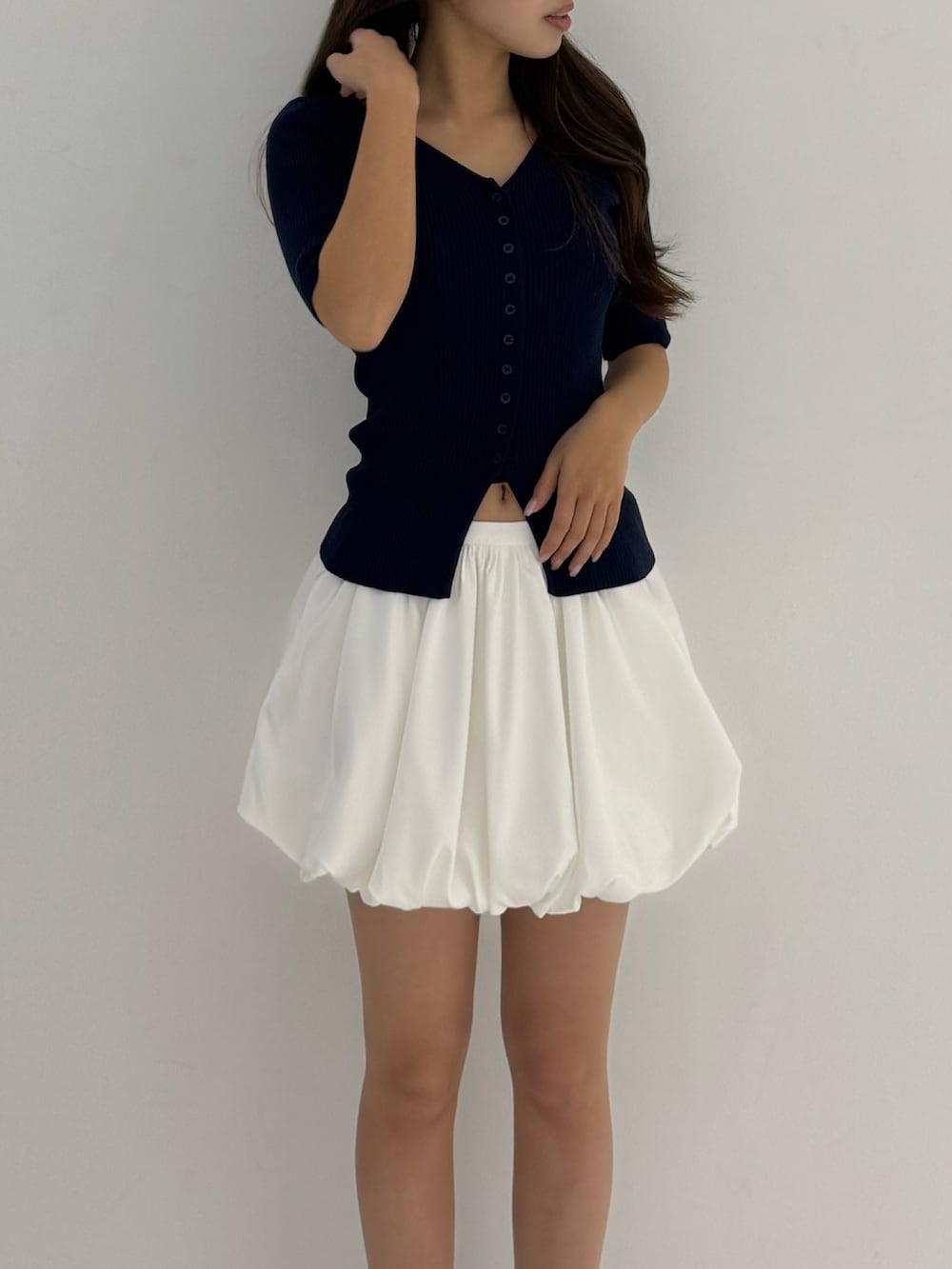 ブルー系のニット/セーター、ホワイト系のスカート、ブラック系のローファーを着用したレディースの春コーディネートの2枚目の写真