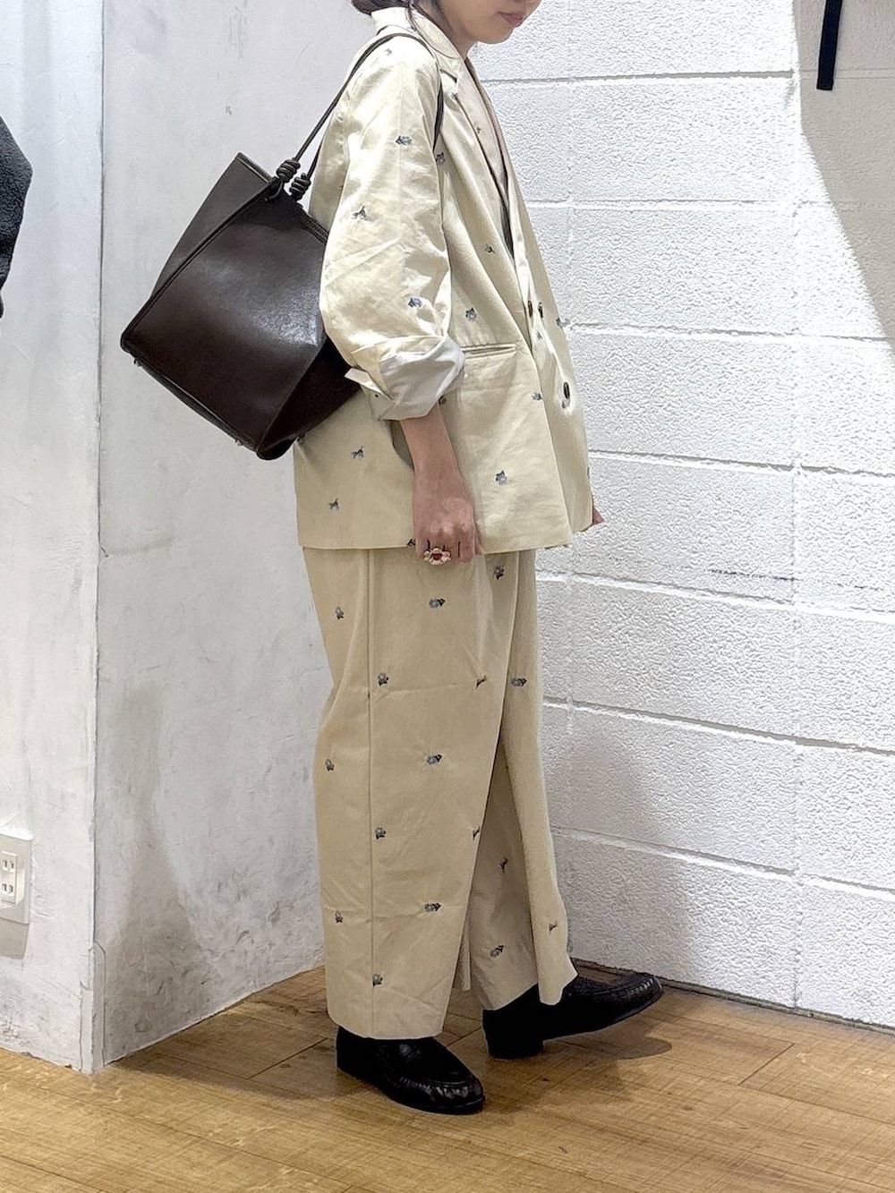 ホワイト系のタンクトップ、ブラウン系のトートバッグ、ベージュ系のその他アウターを着用したレディースの春コーディネートの2枚目の写真