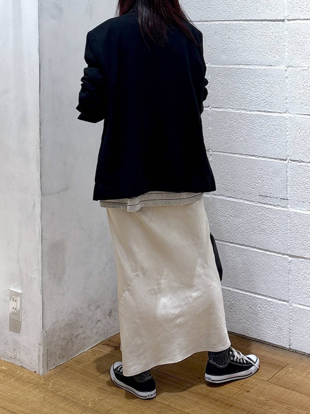 ホワイト系のスカート、ブラック系のテーラードジャケット、ブラック系のショルダーバッグを着用したレディースの冬コーディネートの3枚目の写真