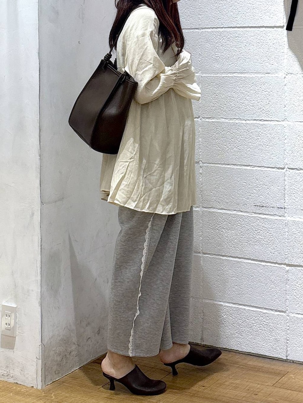 グレー系のスウェットパンツ、ブラウン系のサンダル、ホワイト系のシャツ/ブラウスを着用したレディースの春コーディネートの2枚目の写真