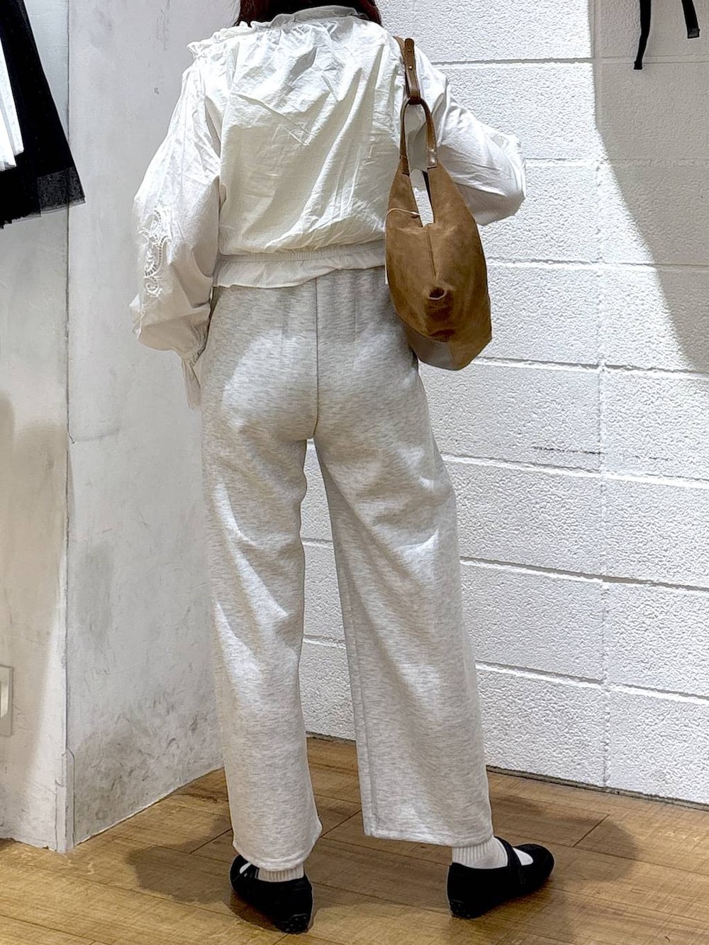 グレー系のスウェットパンツ、ブラック系のスニーカー、ホワイト系のシャツ/ブラウスを着用したレディースの春コーディネートの3枚目の写真