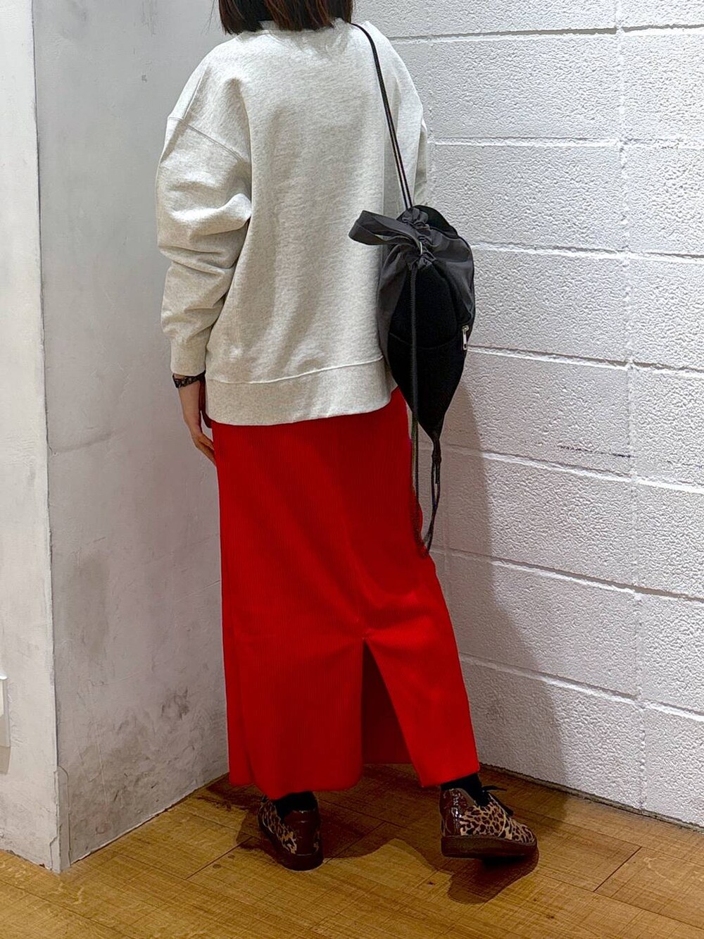 レッド系のスカート、グレー系のスウェット、ブラック系のバックパック/リュックを着用したレディースの冬コーディネートの3枚目の写真