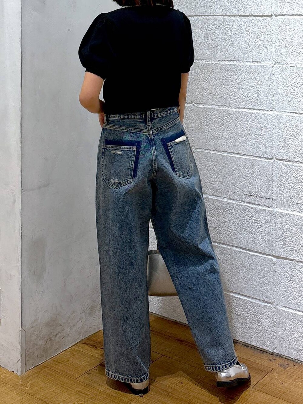 シルバー系のショルダーバッグ、シルバー系のローファー、ブルー系のデニムパンツを着用したレディースの冬コーディネートの3枚目の写真