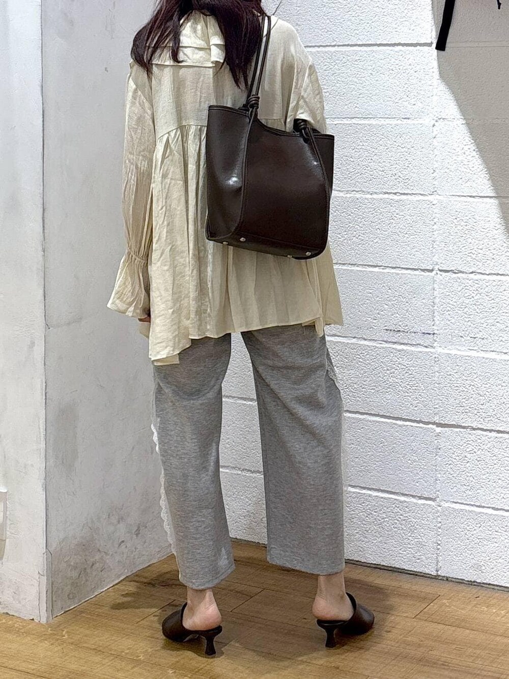 グレー系のスウェットパンツ、ブラウン系のサンダル、ホワイト系のシャツ/ブラウスを着用したレディースの春コーディネートの3枚目の写真