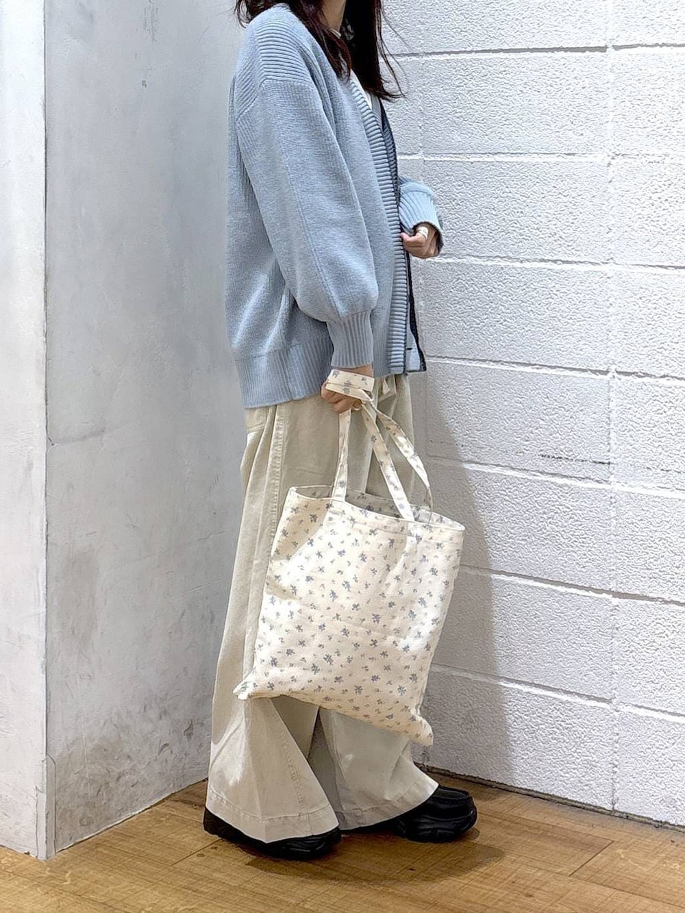 その他のトートバッグ、ブルー系のカーディガン/ボレロ、ホワイト系のデニムパンツを着用したレディースの冬コーディネートの2枚目の写真