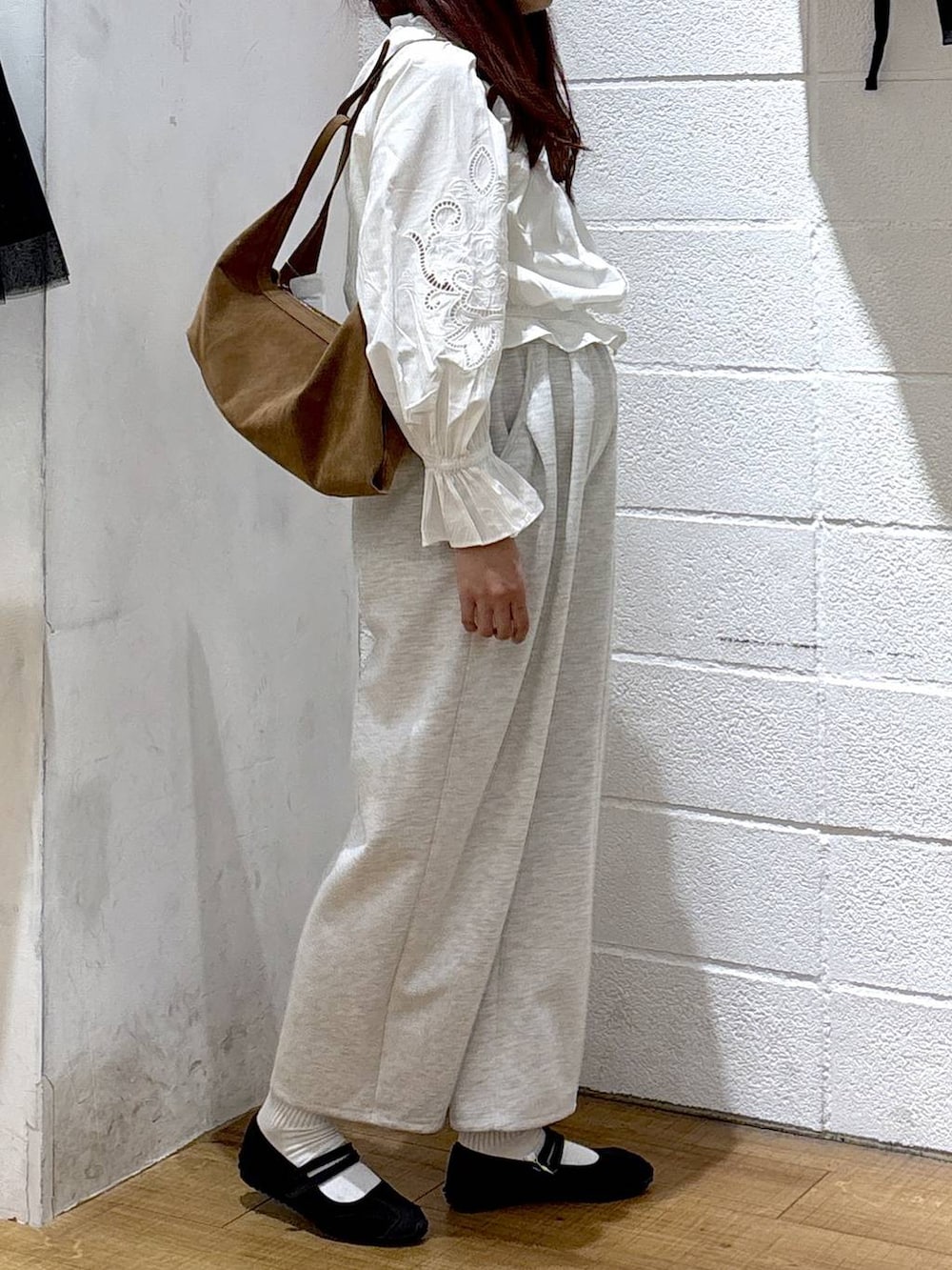 グレー系のスウェットパンツ、ブラック系のスニーカー、ホワイト系のシャツ/ブラウスを着用したレディースの春コーディネートの2枚目の写真